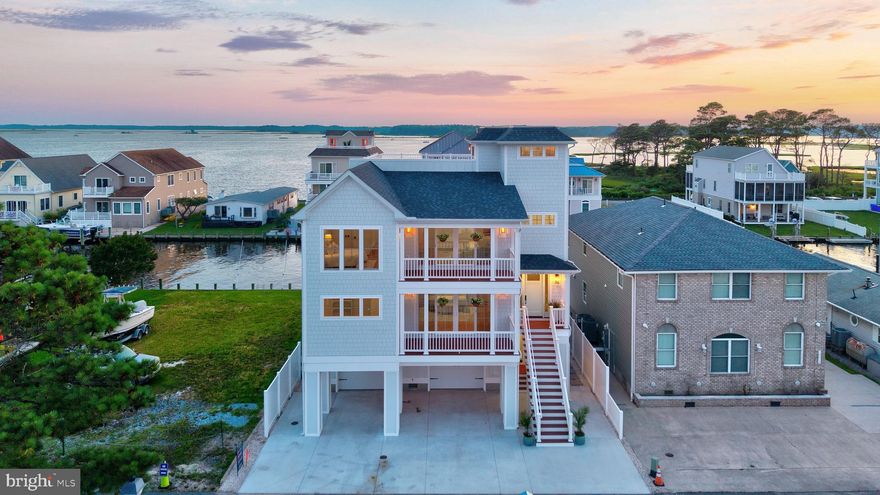 Nestled along a tranquil canal, this magnificent brand new construction 6-bedroom, 5 full+2 half bathroom masterpiece awaits you. Crafted with unparalleled attention to detail, this residence is a testament to luxury living at its finest. From the moment you enter, you're sure to be captivated by the impeccable designer finishes that adorn every corner of the over 5,000+ sqf residence, creating an ambiance of refined coastal living – not to be missed is the custom 8’ mahogany entry door with sidelights. The main level maintains the open concept living space with gas fireplace and large dining space. At the heart of this home lies a chef's kitchen designed to inspire culinary excellence. Featuring warm shaker cabinets, quartz surfaces with ogee edge island, a  suite of GE Cafe appliances including professional six-burner stove - this kitchen is as functional as it is beautiful. The large pantry ensures ample storage space, making it a dream come true for any gourmet enthusiast. These spaces flow seamlessly to the large covered lanai with fans perfect for outdoor entertaining with views of the canal and bay. Rounding out this level is the primary suite featuring ensuite bathroom, large walk-in closet with custom designed built-in organization finishing off with a private balcony to enjoy your morning coffee or nightcap. As you ascend the custom stained stairs to the upper level you are greeted by an open flex space perfect for a secondary living space or office just down the hall from the oversized laundry room. This level maintains three bedrooms along with a secondary primary bedroom with ensuite bath featuring a roman bathtub, shower and ample closet space. The fourth floor of this residence maintains a wet bar with indoor/outdoor window allowing easily made pass through of drinks on those warm summer evenings. There is a half bath on this level with designer wallpaper – so guests can comfortably enjoy the expansive roof deck with breathtaking views from the glistening bay views to the serene wetlands and the iconic skyline of Ocean City. Immerse yourself in the epitome of luxury as you entertain guests amidst the backdrop of breathtaking sunsets or simply bask in the tranquility of your own private oasis.. The roof deck is rated to handle the weight of a hot tub and has water and electric run if you should wish to have one installed. Whether you seek solitude in your private sanctuary or wish to entertain guests with unparalleled hospitality, every inch of this home promises pure bliss. In addition to the stunning aspects of this home, the developer has also paid special attention to the structural integrity of the home such as structural piling foundation, structural steel beams on ground floor and main level, 2" x 6" structural framing, elevator ready stacked closets with power, a built-in fire suppression systm…and the list goes on. 
With ample space for friends and family, lounging, and soaking in the sun, every moment spent outdoors is a celebration of the good life.
Whether you're seeking a serene escape or an outstanding space for entertaining, this canal-front haven promises an unparalleled living experience. Don't miss your chance to own a slice of paradise where luxury meets waterfront bliss. This home is minutes away from Fenwick Island, Delaware state park beaches and the Freeman Stage for all of their amazing headlining concerts in addition to restaurants, grocery, shopping & Ocean City, Maryland. Schedule your private tour today and let your dreams set sail! *The community of Cape Windsor provides a community pool, tot lot & small beach area for crabbing & fishing.