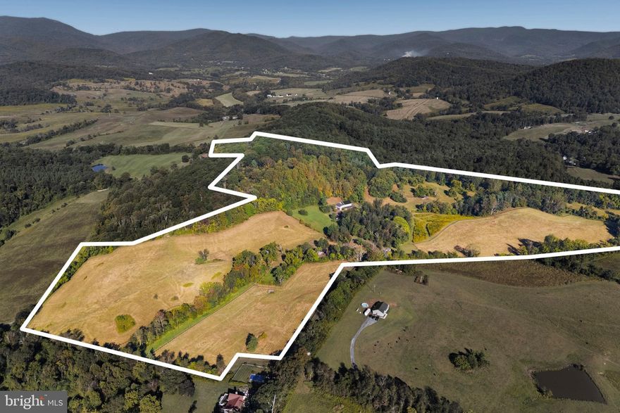 Do you dream of room to roam in the rolling foothills of Rappahannock County? Fox Hill is a dream come true in the heart of Virginia's Piedmont. Verdant pastures undulate and meet lush forest on the flanks of Mason Mountain. Take in the ever-present views of Piedmont hills, Blue Ridge Mountains and your own private, hidden oasis. This sprawling property is 75 acres in two tax map parcels. 🐎 Fox Hill prominently features a stunning 1800s timber frame bank barn, which was rebuilt on site in 2018. Built on a new, poured concrete foundation, the lower floor is a well-appointed horse stable with 8 stalls, wash stall, feed room, and a sunny tack room with a full bath and kitchenette. 🐎 The upper floor has a very comfortable 1-bedroom apartment at its southern end. It is thoughtfully designed with high ceilings and oversized windows to let in the light. There is a bath with heated slate floors, a generous walk-in closet, and details like antique barn wood trim. The structure has Hardiplank siding and a standing-seam metal roof, providing low maintenance and longevity. 🐎 In addition to the apartment, the upper floor of the barn has a breathtaking, 3-story unfinished space. With a striking modern glass wall and door at the entrance, and authentic pegged timber frame construction, possibilities abound. This could be a stunning expansion of the living space, an impressive event venue, or maybe a tasting room for a farm winery or brewery. A septic system for 5 bedrooms is already in place and allows for either building a separate home uphill of the barn, or converting the barn space. 🐎 Fox Hill has 5 separately fenced pastures, a large run-in shed for horses, automatic waterers, and cattle sorting and loading infrastructure. Additionally, there is a machine shop/shed with electricity and a woodstove-heated workspace. The property is in the heart of the Thornton Hill Hounds foxhunting territory and is a short drive to several other hunts. Historic Warrenton and Upperville horse show grounds are each around an hour's drive, as are many other training and show facilities. 🐎 Rappahannock and surrounding counties offer endless recreational possibilities. Nearby Shenandoah National Park is home to scenic Skyline Drive with its overlooks as well as many miles of trails. There are wineries and breweries, great restaurants and cafes, antique stores, farms and orchards, and much more. Looking for cultural activities? Visit one of the many art galleries, attend a play or a concert at one of the theaters, or visit the Rappahannock Historical Society’s museum. 🐎 Near Sperryville and “little” Washington, and convenient to Warrenton and Culpeper, Fox Hill is ideally situated for full-time residents or weekenders alike. Located less than two hours from Washington, DC, and just over an hour from Charlottesville, the property is within an easy driving distance for weekend getaways.