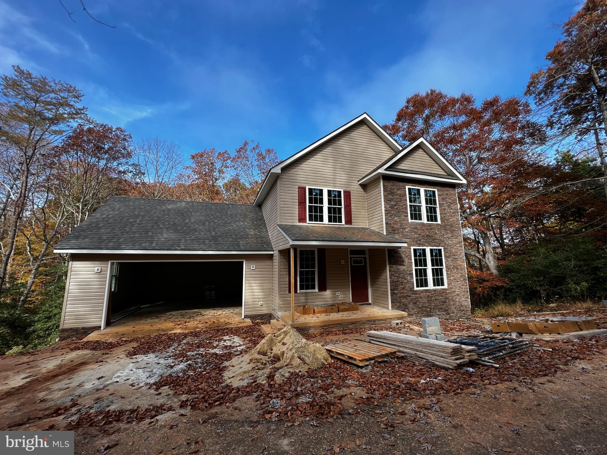 Attractive new construction home with stone accent on scenic wooded lot. Nearly one full acre, private setting, right in town, close to everything you need. 3 bed, 2 full, 2 half baths. Kitchen will be complete with granite counters, an island and stainless steel appliances. Finished basement with home theater room. Front porch. Over-sized garage, 24'x24'. All electric home. Private well & septic. No HOA!