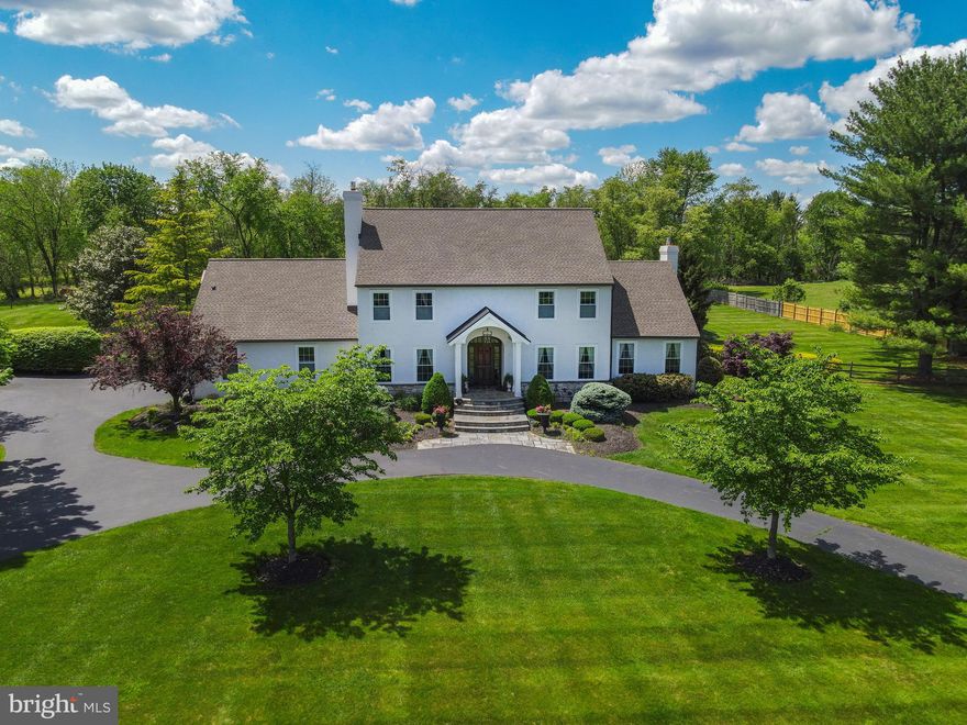 Nestled on a serene country road in the highly sought-after Council Rock School District, this stunning home at 1071 Highland Road offers the perfect blend of luxury, privacy, and practicality, with the added benefit of low taxes! Completely remodeled over the past three years, this 4-bedroom, 3.5-bathroom home boasts 4,000 square feet of beautifully designed living space on 3 acres of privacy backing up to a thick layer of trees. A circular driveway and flagstone entry lead you to a home that’s been thoughtfully transformed from top to bottom, featuring wide-plank luxury vinyl flooring, richly detailed custom millwork, recessed lighting throughout, and a soft, neutral color palette. The craftsmanship is exceptional, with elegant coffered ceilings in the family room, refined crown molding, stately fireplace surrounds, classic wall panels, and intricate dental molding that together create a sense of timeless sophistication. The heart of the home is the elegant white kitchen with light quartz countertops, two sinks, a large double waterfall central island with ample seating, bay window that overlooks the yard and pool, and top-of-the-line stainless HESTAN appliances. The newly built sunroom is a showstopper with soaring ceilings, oversized windows, and its own HVAC system for year-round enjoyment. The main level also features a formal dining room, living room, and a private office—offering a perfect balance of spaces for both relaxation and productivity. The main bedroom suite offers a peaceful retreat with a sitting area, multiple closets, and a spa-like bath featuring a heated floor, steam shower and oversized cast iron tub. Down the hall, you will find three other bedrooms and a sleek, modern bath that offers a generously sized walk-in shower. A standout feature of the home is the brand-new cabana wing with a full wet-room bath (zero-entry shower), laundry room, and butler’s pantry—ideal for seamless indoor-outdoor living. Designed with entertaining and relaxation in mind, the spectacular backyard is a private oasis with a saltwater inground pool featuring a lounging area and waterfall. The lighted pergola next to the pool offers the perfect setting for daytime relaxation and magical evenings alike. Just steps away, the charming flagstone patio has a partial stone wall and features a built-in grill—perfect for al fresco cooking and outdoor dining with family and friends. Additional highlights include two fireplaces, 2-zone geothermal heating and cooling, a whole-house water purification system, and reverse osmosis for drinking water and ice. 1071 Highland Road offers a rare opportunity to enjoy refined country living with modern amenities in one of Bucks County’s most desirable locations.