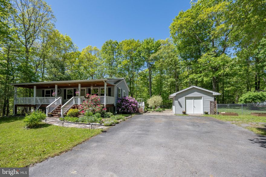 When you pull into the driveway you will know this will be your new home!  You will not believe the curb appeal - from the oversized paved driveway to the hardscaping and beyond. There are numerous plantings, including a pollinator garden and the wooded areas on three sides will give you a feel of privacy.  Also, the exterior of the home features a large covered front, terraced decks and patios in the back of the house.  There is a detached garage, sheds, a fire pit and more.  The front and back yards allow room for the kids, pets and entertaining.  The interior of this three bedroom, two bath house gives you loads of natural sunlight. 
 Two bedrooms and a bath, plus a kitchen, living and dining area are on the main level.   You will have a large family/common area in the lower level which includes a combination wood and coal stove for easy heating in the winter.  This level gives you the third bedroom, second bath and laundry room.  Heat is a combination of propane wall unit, electric baseboard and wood stove.  Flooring is hardwood, laminate, carpet and concrete. There are many more features that complete the home and property.  Put this on your must see list.  24 hour notice needed for all showings.  Call for more details.  Don't miss this opportunity.