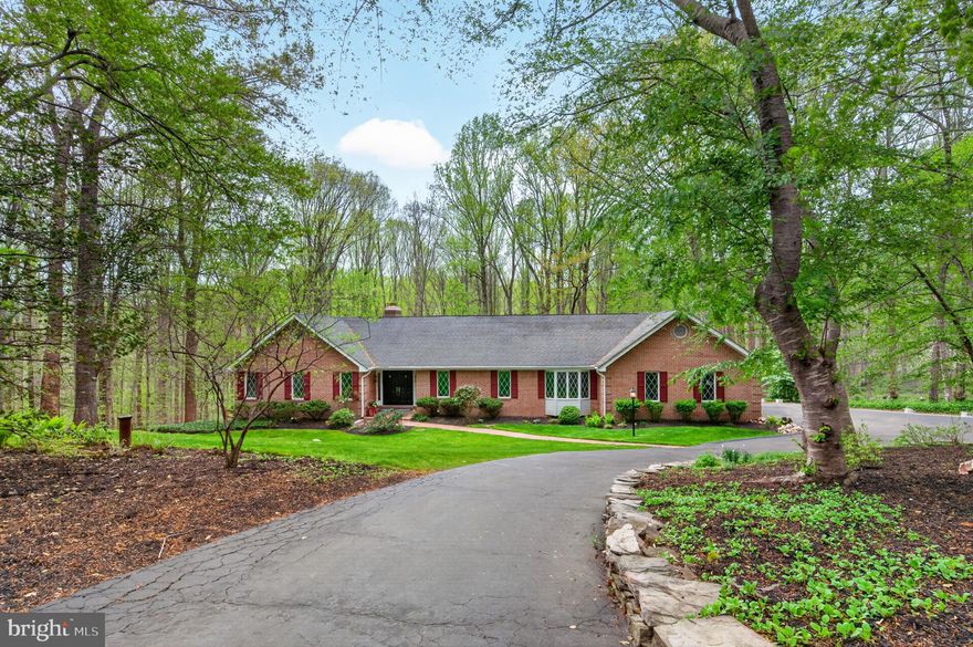 A unique and rare find! This incredible two level, custom ranch, is set in the sought after equestrian community of Plantation Hills,  deep in the heart of Clifton Virginia. Plantation Hills embodies the gorgeous Virginia natural forests,  soft topography, flora & Fauna and stunning varietal homes.  The  lot is to die for. 5.19 acres of mature trees, just enough clear space, and private driveway with circular entrances leads you to the home.  Just enough open yard space surrounds the house, providing sunlit social-play space & gardening. A quaint trail takes you back to the historical Wolfe Run Stream which meanders along the rear lot border. Simply stunning setting & nature and views!  The three sided Brick house has a large two car, side load garage and boasts wonderful architectural features. The open floor plan is accented with Soaring vaulted ceiling on the man level, freshly painted throughout   the loads of natural light is enhanced by four skylights and a wall of windows w/ french doors, leading to a incredible rear deck. The backyard vista is amazing! An open kitchen features a center island, custom cherry cabinets and granite countertops, top grade back appliances and recessed lighting throughout, complimented by a casual breakfast area and an adjacent formal dining room! The family room across from the kitchen  has a wood burning fireplace with brick hearth , vaulted ceiling and french doors to the deck.   The main level is covered with newly refinished natural hardwoods. The unique floor plan has the primary suite on the main level with a large luxury bathroom walk in closet and cathedral ceilings! Enjoy a morning walk out from the french doors to the rear deck to an immense,  serene natural settling. The fully finished basement features an large rec-room, wood burning fireplace, fresh paint and new luxury vinyl plank flooring! Two large bedrooms and a full bath! Generous storage space and laundry room are on the lower level, and best of all; a full walk to a flagstone patio.  A downsizers dream with main level owner's suite.  Enjoy top ranked pyramid of Fairfax County Public Schools! Close to Old Town Clifton & easy access to main Thoroughfares for commuters. Come see this Gem! Open Saturday & Sunday! Contact me directly for private showings.