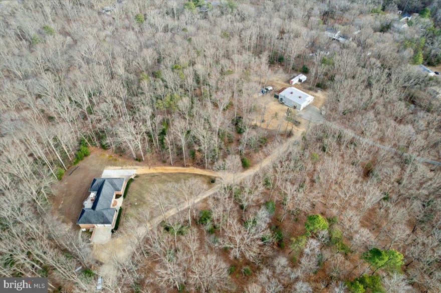 SHOP AND RESIDENCE on 18+ ACRES. All brick rambler on 18.64 acres of wooded, private land offering exceptional craftsmanship and versatility.  Geothermal heat pumps and Andersen windows, extensive power supply specs are just a couple of the steps taken by the owner to make this a long-lasting home. Dual shop areas on the property. A 3 bay space in the lower level of the home and a large shop buiding separate from the home address.  The 4-bedroom, 4.5-bath brick residence features a massive central great room with vaulted ceilings and a striking masonry fireplace with custom wood elevator.  The adjacent gourmet kitchen is designed for both function and style, featuring stainless steel appliances, custom backsplash, and a huge center island. The large main level owner's suite is large in scale with huge closet and bath. Owner's shower has body sprays, corner tub is jetted! This suite also enjoys access to the rear patio. Two more large bedrooms share a second full bath, and the laundry room is on this main level as well. The entire floor plan is perfect for large gatherings, making lasting memories, holiday events. The finished basement includes a small in-law apartment, mechanical room and storage, room for a large recreation room. Outdoor living areas are equally impressive, with two levels of poured concrete patios, including a built-in grill station off of the kitchen. Car enthusiasts and hobbyists will appreciate the two garages within the home, totaling 5 bays. Lower level garage has another full bath, room for multiple vehicles and shop area, perfect for collectors and mechanics. SHOP BUILDING- a 55 x 60  shop with 14 x 40 addition, covered slab off the back and other various outbuildings for storage various tools and equipment conveyances, offering endless possibilities. Multiple uses with motor lifts, plasma table, air hoist on steel beam from front to back of the main space. The property is conveniently accessible to Route 5 and Route 235, offering easy access to shopping, dining, and commuter routes. SOLD AS IS.