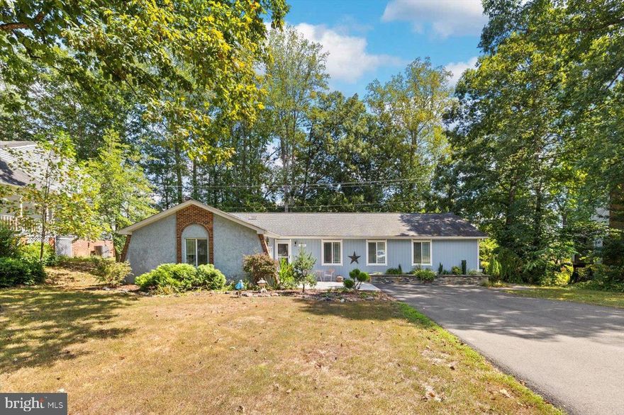 1229 Aquia Drive is more than a home - it is a statement! This main level living home has mid-century flair with magazine worthy renovations. Aquia Harbor is known for its unique lifestyle—gated security, its own fire and police departments, horse stables, a golf course, marina along the Potomac River, clubhouse, in-neighborhood preschool, and miles of trails.  This home has been meticulously enhanced under its current owners’ care since 2010. It boasts four-bedrooms, three-bathrooms and spans more than 2,100 square feet of beautifully reimagined living space. The nearly half-acre lot backs to a walking trail, providing easy access to Government Island, while the exterior makes a lasting impression with its blue-gray façade, stamped concrete patio, and curated landscaping. A spacious driveway and one-car garage (with bonus attic storage and a conveying refrigerator) provide plenty of function to match the style. Step inside through a custom glass entry and discover open, light-filled spaces designed for modern living. The main living area is anchored by a striking arched gas fireplace and flows seamlessly into the kitchen—an HGTV-worthy showcase of custom sage cabinetry, raw quartz countertops, marble backsplash, white GE Café appliances, six-burner gas cooktop, and a farmhouse sink. A matching laundry room with built-ins continues the thoughtful design. The newly added primary suite is a private retreat of nearly 400 square feet. Highlights include an impressive custom closet with organizational shelving and attic access, double door entry, and a spa-inspired bath with a steam/sauna set-up, champagne-gold fixtures, a flat-floor shower with dual showerheads, and a deep soaking tub. Additional bedrooms shine with shaker doors and custom touches—one features its own ensuite with a cast-iron tub and built-ins, another offers a built-in desk wall. The third full bath stuns with marble flooring, rose-gold fixtures, and hand-painted tile. On-demand hot water ensures comfort and efficiency. Outside, a fenced backyard with garden beds awaits your green thumb, while mature ornamental trees and a rear patio create the perfect setting for relaxation. All of this comes with unbeatable convenience: I-95 is less than 5 minutes away, Quantico is just 15 minutes north, and Downtown Fredericksburg is 20 minutes south. Shopping, dining, and daily needs along Route 610 are right at your fingertips. Tucked within this coveted community, 1229 Aquia Drive offers a rare blend of character and top-to-bottom designer renovations. We hope you can come for a tour!