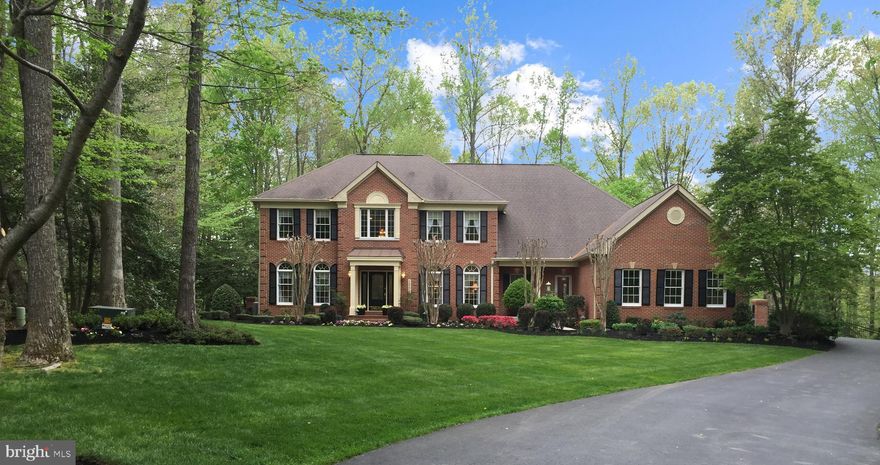 Grand 7500 sq ft colonial has been meticulously maintained by original owner and represents the largest floor plan in Annapolis Preserve. An extended driveway provides the ultimate private setting and also borders community open space. The 2.35acre property displays irrigated manicured grounds with night lighting, and showcases a gunite swimming pool in a beautifully landscaped setting.   A poolside Veranda overlooks the large fenced rear yard and wooded perimeter while offering shade from the sunny pool deck. An impressive 2-story Foyer introduces hardwood floors with generous social spaces, ensuite bedrooms and panoramic views from every room.  The Family Room is located beyond the classic Living Room and Dining Room, and highlights a prominent stone masonry fireplace and Sun Room entry.  This popular Chesapeake floorplan was expanded at construction with a 4-ft extension for an even larger Family Room, Owners Suite and Billiard Room.  Additionally, a Sun Room was added to captures natural light from the skylights in the vaulted ceiling and many windows. A Library with made-to-measure built-ins is tucked away for added privacy.  The Chef’s Kitchen is fully equipped with upgraded appliances, plentiful cabinet and counter space, informal dining with Veranda access and a 2nd staircase for direct access to upper level.  The impressive 1,000+ sq ft Owners Suite reveals a spacious bedroom with tray ceiling, separate dressing room, private deck and distinctive renovated Luxury Bath, featuring handsome marble flooring, stone-top vanities, striking marble basketweave wall tile, a large slipper tub and deluxe marble shower.  A 24 X 12 deck was later constructed off the Owners Suite with synthetic materials and tempered glass panels for a birds eye view and clear sightlines. Other 3 ensuite bedrooms present lovely views and unexpected closet space.  The fully finished lower level with 9 ft ceilings is comprised of an Office with built-in desk, TV Room, 5th full bath with changing area for the pool, a Billiard Room and custom crafted Bar with space for game tables and seating, and a large Gym with potential for 5th bedroom.