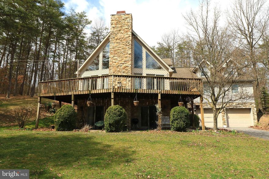 Live like you're on vacation all year round near Lake Raystown residing just 2 minutes from the 7 Points Marina. Visit this must-see 5-bedroom, 3-bath home designed for one-floor living. The main floor is an open concept with cathedral ceilings and large windows to view nature at its finest. Also on this level are two bedrooms, hardwood floors, a gas fireplace, full bath, laundry, and a spacious eat-in-kitchen complete with a 2-car garage connected by a breezeway. Walk upstairs to a third-floor loft containing a large 3rd bedroom with owner's bath and separate bonus room. The lower level is well-lit with natural light also boasting an open-concept floor plan equipped with a second gas fireplace, 2 bedrooms, full bath and laundry room in addition to an attached 2-car garage. Looking for an investment property for air B&B or bed and breakfast accommodating up to 22 people? Having two full kitchens, benefit by staying on one floor while you rent out the other! Enjoy your wraparound deck while catching a glimpse of wildlife with this home sitting on a private, 
2.46-acre wooded lot in the desirable Lakeland Pines Development. Near Pennsylvania State Game Land and Lake Raystown, you'll have the luxury of being minutes from fishing, hunting, boating, hiking, and more! A remarkable opportunity awaits owner-occupiers and investors alike. Schedule a tour today.