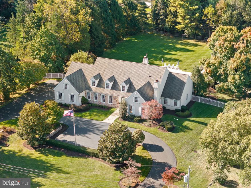 Nestled on one of the most prestigious streets in Newtown Square is this expansive, custom-built beauty situated on an extraordinary, level 1.44 acres.  This property is one of the most idolized by its neighbors for its sprawling lot, its resort-like feel, and its close proximity to the highly esteemed, Aronimink Golf Club (home to the 2026 PGA Tour)! This home, iconically known as the “19th Hole” to many, is a country club all its own.
A gorgeous stone and stucco home that exudes charm and provides unparalleled curb appeal. Drive down the stately circular drive and enter the front door to the Grand 2-story Foyer.  You will notice gleaming hardwood floors, crystal chandelier and an elegant, curved staircase. The formal Dining & Living Rooms to your left and right look like they are straight out of a magazine, and much more spacious than in most new- builds these days.  Continue straight into the entertainment “heart” of the home.  The open floorplan here includes a large Kitchen, with beautiful Kountry Kraft cabinetry to the ceiling, an 8 ft. island with seating for 6, Thermador range, double ovens, and much more.  A conveniently placed Mudroom with access to the HEATED 3 Car Garage, Powder Room, Pantry, and Laundry Room are tucked away on one end of the Kitchen while the opposite end of the Kitchen flows into the spacious 2 Story Great Room, and light-filled Breakfast Room. The Breakfast Room overlooks the stunning heated pool, exquisite stone pool house (with full bath) and extensive covered patio. Step outside to experience it all! Look beyond the pool to the fully fenced-in football field sized backyard.  This spectacular setting is the perfect stage for making memories that will last a lifetime.  This was the beloved location of many parties, games, and family gatherings over the years.  An entertainer’s dream!! Step back inside, through the 2-story Family Room, past the cozy gas fireplace and beautiful custom built-in entertainment center, and 2nd Powder Room, to enter the first-floor Grande Primary Suite.  It is apparent that no expense was spared when planning this dream room! Take note of the tall tray ceiling, custom built-in cabinetry, boudoir, “his and her” custom closets, and sitting room/home office. The adjacent spa-like bathroom boasts a soaking tub, glass stall shower, private water closet, and his and her separate vanities on opposite sides of the room! 
Next, move on to explore the 2nd floor, where you will find 3 spacious bedrooms, one with an ensuite bathroom, and 2 more that share a “Jack-n-Jill” style bathroom. There is also a large Cedar Closet, as well as one finished bedroom-sized room that could be a 5th bedroom if a window is added. There is also unfinished space beyond the back bedroom that could be a walk-in closet or generously sized bathroom- the possibilities are endless! On to the lower level…. the true 19th hole of the home. Here you will find 2,500 sq. ft. of space outfitted with a handsome large wooden wet bar, room for pool table, seating and loads of entertainment space.  The most exciting feature of this level is the back-lit faux windows that were custom made to provide the feel of looking out over the golf course! Truly a must-see feature and conversation piece! There is also a large, finished bonus room that could serve as a gym, au-pair suite, play/craft room or home office.  Adjacent to this Bonus Room is a full bathroom with shower/tub for added convenience. 
Additional features of the home include a full home generator, central vacuum system, security alarm system, home speaker system and stadium level spotlights for the back yard, installed to enhance those fun summer night yard games! All of this within 5 minutes to EPISCOPAL ACADEMY, Wayne/Main Line, the new shops and restaurants at ELLIS PRESERVE, and centrally located to Routes 3 (West Chester Pike), 252, and 476!