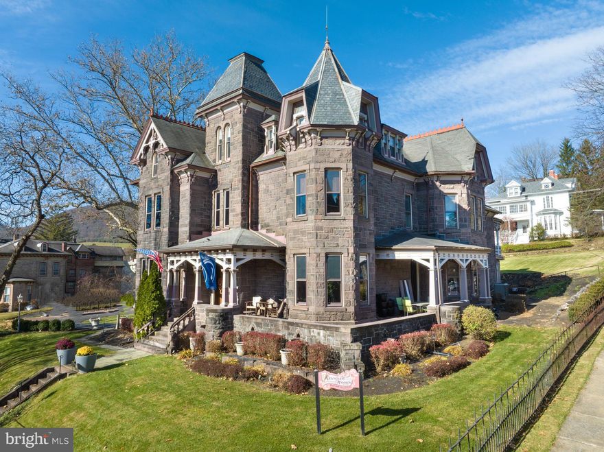 The iconic and stunning Reynolds Mansion in Bellefonte could be yours! This highly successful Bed & Breakfast is turnkey and has so much beauty and uniqueness to offer. There are 10 guest bedrooms in the mansion with on-suite bathrooms that are all uniquely designed and different, appealing to so many guests, especially return guests. As you step into each highly appointed room, you will be amazed at all the attention to detail and extra touches to make this one of the most enjoyable stays for your guests. Two half baths, laundry room, office and storage space can be found on the first floor as well. A private owners’ suite in the mansion provides the 11th bedroom and allows you to conveniently live at the property while attending to guests.There is also a stunning carriage house with two separate 1 bed/1 bath guest suites, each with fantastic finishes and privacy along with a convenient laundry room. The carriage house also offers a 2 bed/1 full bath apartment that is leased by the year. With the stunning stone exterior, 8 original fireplaces, exquisite Walnut woodwork and moldings along with pristine attention to detail throughout, there is nothing more to do here than impress your guests. 12 parking spaces are also included. Don't miss this piece of history!
