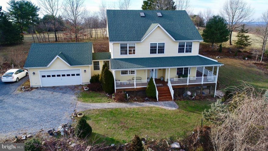 Enjoy serene mountain views from this beautiful farmhouse in Hedgesville, WV! 4 bedrooms, 3.5 bathrooms. Over 3,800 square feet of living space. Immaculate hardwood floors throughout the home. The family room is bright and sunny with brick fireplace. Gourmet kitchen with upgraded countertops and stainless steel appliances. Formal dining area off the kitchen and a separate formal living room. Master bedroom has plenty of light with an attached luxury master bathroom featuring a soaking tub and walk-in shower. The lower level is finished with a family room and study. Sustainable living with geothermal heating and air conditioning. The property boasts a gorgeous wrap around porch, stone patio, and attached 2 car garage. Fantastic mountain views from every angle on over 3 acres!