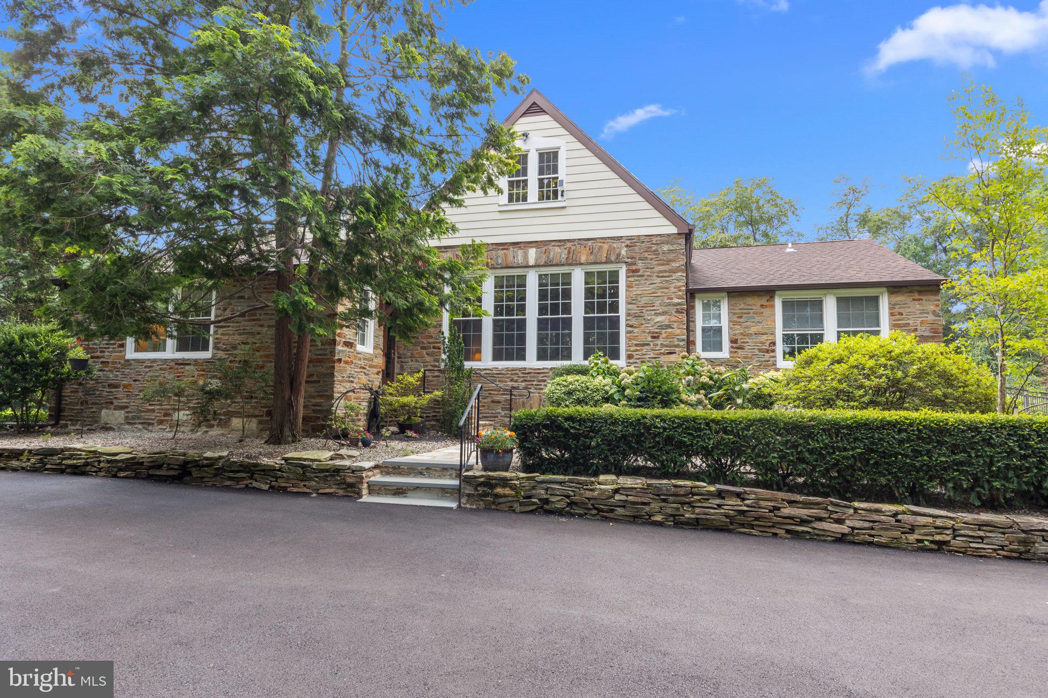 Set on just under an acre of beautifully landscaped grounds, this stunning 1930 Tudor home with a first floor Primary bedroom offers the perfect blend of timeless charm and character with modern comfort. From the moment you arrive, the architectural detail is evident. Inside, the bright and spacious great room features 7-foot elongated windows on two walls, deep windowsills, and a handsome wood-burning fireplace with Mueller Mosaic tile (of Trenton) and a custom wood mantel. The fully renovated kitchen boasts soft-close maple cabinetry, quartz countertops, a classic subway tile backsplash, porcelain tile flooring, stainless steel appliances including a gas cooktop and electric oven, a deep stainless steel farmhouse sink, and recessed LED lighting. Adjoining the kitchen, the sunny breakfast room features glass pocket doors that open seamlessly into the formal dining room. The first-floor primary suite is a true retreat, offering three closets (one plumbed for a washer and dryer), private access to a deck overlooking the serene backyard and saltwater pool, and a discreetly located handicap-accessible ramp for convenience. The luxurious en-suite bath features radiant heated floors, dual marble vanities, a soaking tub, custom tiled glass shower, and a private water closet. The living room and charming powder room with whimsical designer wallpaper completes the main level. Upstairs, you’ll find two spacious bedrooms, a full hall bath, and a versatile bonus room—perfect as an office or potential fourth bedroom. Built-in drawers and custom shelving add both charm and functionality. The finished lower level includes a well-appointed laundry area with utility sink and countertop space, as well as interior access to the garage. Step outside to your own private oasis featuring a heated saltwater pool and a fully equipped outdoor kitchen, ideal for hosting summer gatherings. Additional upgrades include: newer windows throughout, newly refinished hardwood floors, whole-house Generac generator, a spacious shed, updated interior doors throughout, newer roof and gutter guards. This one-of-a-kind property offers the rare combination of vintage character, thoughtful renovations, and modern conveniences. NOT in the flood plain, this home is ideally situated within walking distance of the Delaware River, historic Canal Path, and Yardley Boro, and offering easy access to major roadways and trains to Philadelphia and New York, the home is as convenient as it is captivating. Don’t miss the opportunity to call this exceptional home your own.