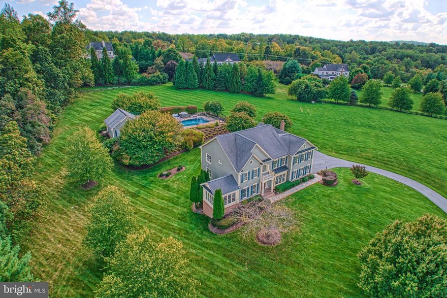 This beautifully crafted Beacon Hill retreat welcomes, as traditional hues and sun-kissed professional landscaping set a swoon-worthy setting of idyllic curb appeal, enviable outdoor entertaining, and refined interiors. Within, 6,175 square feet are flowing and cheerful where crisp hues, hardwoods, handsome pillars, french doors, handcrafted built-ins, and endless trimmings add architectural interest to rooms for gathering, work, and play. Enjoy both everyday living and celebrations within the sunroom, bookshelf-clad office, soaring living room with stone-wrapped hearth, and gourmet kitchen of high-end appliances, island cooktop, and countertops of stone. Outside, a 4.5 acre retreat for fair-weather-fun invites you to explore. On spectacularly landscaped grounds, host al fresco dinner parties overlooking sweeping sunset skies, stroll by ornamental trees dotting meandering paths, gather for cake in the gazebo, and invite friends to the pool where lightscaping and water features inspire after hours-parties. Here, refresh and unwind within a thoughtful pool house - completed by kitchen and bath amenities - and consider the workshop potential of the lower-level garage plus storage space. Five spacious bedrooms partner with modern baths to refresh and soothe. In the primary, get cozy within the sitting room, and start your day with the help of dual closets and a luxurious bath boasting rain shower and freestanding place for bubbles.  While on tour, ask after recent updates, imagine casual game nights with overnight guests in the lower-level, and visit your two car garage; perfect for weekend projects and launching Wine Country adventures.  From home, morning runs along neighborhood trails promise wildlife sightings, while proximity to commuter and entertainment routes lead to historic townships, parks, dining, electric OneLoudoun, Dulles International Airport, and all greater Loudoun County has to offer.