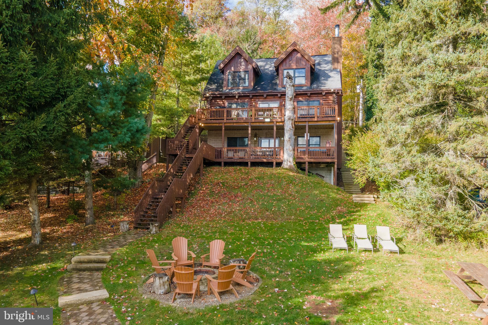 Lakefront Log Home at Deep Creek Lake - Anchored by lake views, this three-level getaway leans into the landscape, just minutes from Wisp Resort! Two tiers of lakefront decking framed by 60 feet of shoreline with a deeded Type A dock. Inside: six bedrooms, four and a half baths, two fireplaces, and 2,600+ square feet of rustic vibes and open flow. Hardwood floors run through the main level’s kitchen, dining, and living areas. The finished walk-out basement adds a lounge, wet bar, and arcade. Updated furnishings throughout. Covered hot tub, gas grill, and lakeside fire pit offer abundant outdoor living space. An established vacation rental, “The Treehouse” already has over $70k of gross rental income on the books for 2025. If you’re looking for the perfect blend of lakefront living meets cabin in the trees – Don’t miss your chance to see this one in person, call today for your private showing!