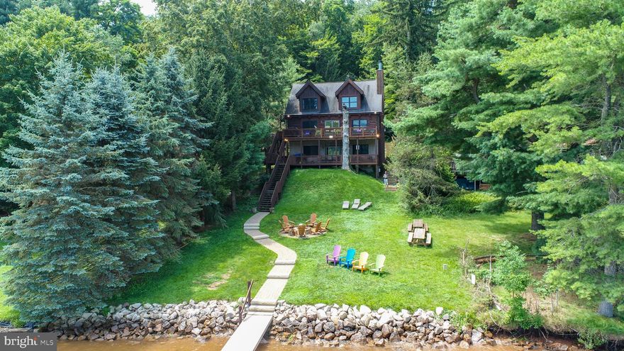 Lakefront Log Home at Deep Creek Lake - Anchored by lake views, this three-level getaway leans into the landscape, just minutes from Wisp Resort! Two tiers of lakefront decking framed by 60 feet of shoreline with a deeded Type A dock. Inside: six bedrooms, four and a half baths, two fireplaces, and 2,600+ square feet of rustic vibes and open flow. Hardwood floors run through the main level’s kitchen, dining, and living areas. The finished walk-out basement adds a lounge, wet bar, and arcade. Updated furnishings throughout. Covered hot tub, gas grill, and lakeside fire pit offer abundant outdoor living space. An established vacation rental, “The Treehouse” already has over $70k of gross rental income on the books for 2025. If you’re looking for the perfect blend of lakefront living meets cabin in the trees – Don’t miss your chance to see this one in person, call today for your private showing!