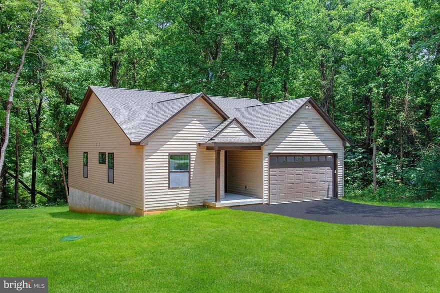 This brand-new build combines modern style with a serene natural setting, situated on nearly one acre with a private deck overlooking peaceful woods. Recently completed and move-in ready, this home offers the perfect blend of elegance and comfort.

Step inside to an open, light-filled floor plan, highlighted by 12-foot vaulted ceilings in the great room that create an airy, inviting feel. The primary suite also features a vaulted ceiling, adding a sense of luxury and spaciousness. For enhanced comfort and privacy, sound-deadening insulation has been installed between bedroom walls.

The gourmet kitchen opens seamlessly to the main living area, making it ideal for entertaining. With three generously sized bedrooms, each with oversized closets, and two beautifully finished bathrooms, there’s room for everyone. The oversized two-car garage includes a high door to easily accommodate SUVs, while the freshly paved asphalt driveway and newly graded, seeded, and strawed yard complete the exterior.

Located in a desirable community, residents enjoy outstanding amenities: a clubhouse for gatherings, a swimming pool, and Sharks Tooth Beach on the Potomac River, perfect for beachcombing and picnics. Outdoor enthusiasts will love Lake Independence, a freshwater lake for swimming, fishing, and non-gas boating, along with a marina and boat ramps providing direct access to Currioman Bay and the Potomac River. Tennis courts, a playground, and picnic pavilion offer year round recreation and community fun.

Experience the best of modern living and peaceful wooded privacy paired with the convenience of vibrant community amenities.