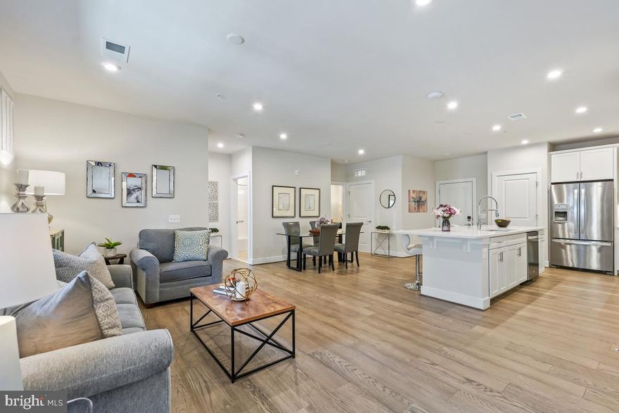 Great opportunity to own this stunning 2-bedroom, 2-bathroom condo with an additional office/den in the highly sought-after Flats at Metropark at Arrowbrook! Built in 2021, this luxurious residence offers over 1,500 square feet of elegant, single-level living on the first floor.

Featuring soaring ceilings, gleaming hardwood floors, and a chef's dream kitchen, this unit epitomizes modern sophistication. The open-concept kitchen boasts a large island, shaker cabinets, soft-close drawers, quartz countertops, premium stainless steel appliances, and a stylish backsplash. The expansive living and dining areas seamlessly flow together, creating the perfect space for entertaining, with access to your private balcony.

The primary suite is both spacious and inviting, featuring a custom walk-in closet and a spa-like en suite bathroom with a double vanity and oversized walk-in shower with dual shower heads. A second large bedroom, hall bath with a shower/tub combo, and a versatile office/den provide flexibility and functionality. Plus, the full-size laundry room offers additional storage for ultimate convenience.

This unit includes two assigned parking spaces in the garage and one parking space in the parking lot. The community amenities are unparalleled, offering a tot lot, playground, dog park, walking trail to metro, basketball courts, tennis courts, and more. Minutes from Innovation Center and Dulles Airport, this turnkey home is a must see.