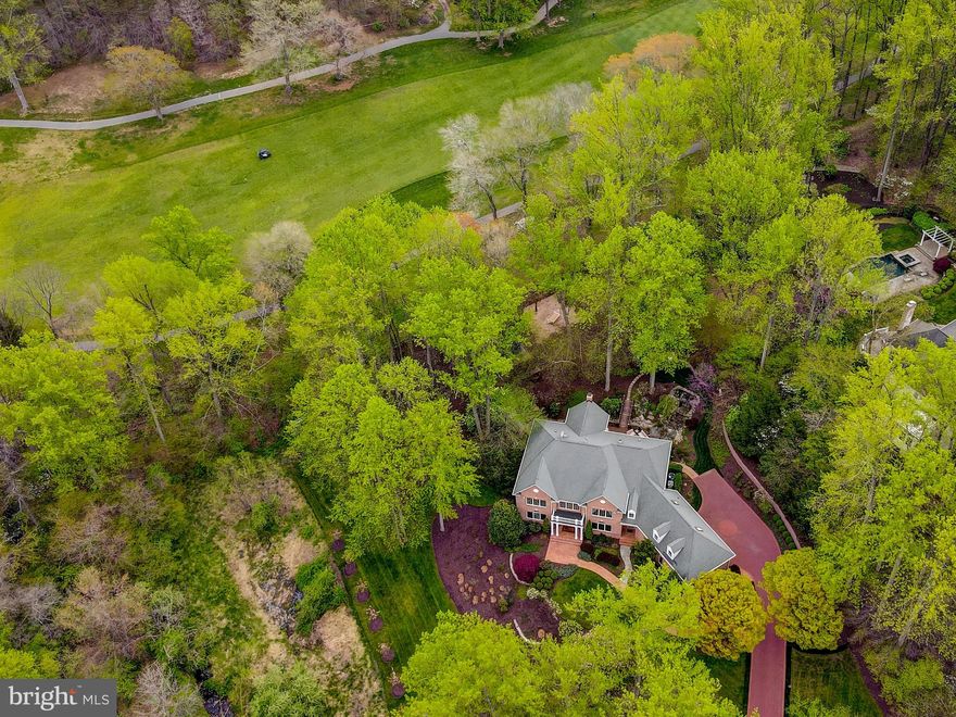 Exceptionally rare golf course-orientated property in Howard County!  Backs to the 12th hole fairway of Hobbit's Glen Golf Course.  Located in the estate-quality community of Forest Glen, this impressive, four-side brick Williamsburg Builders home with a side-entry, three-car garage is among those with the highest of elevations. The completely custom construction combines with an idyllic setting of mature specimen trees, a re-circulating stream with waterfalls, and a view of the manicured greens of the Hobbit's Glen Golf Course to bring a residence and location that few will match. An elegant entry foyer with turned-stair, columned entries, two-story ceiling heights, and a second-floor overlook frame the open floor plan, and the selection of natural materials and designer decor blend attraction. Formal spaces spill into casual family areas to elevate intimate home living as well as the entertainment opportunity experience. A dramatic family room with a floor-to-ceiling stone fireplace flows into a designer kitchen featuring high-end and quality improvements. The Italian Fusion marble countertops are works of art and your gourmet chef will beam with excitement at the sight of the thoughtful workflow and placement of specialty appliances including under-counter refrigerators and built-in Miele coffee center. Glass doors lead to a rich Mahogany wood deck and footbridge overlooking the award-winning hardscape and landscaping featuring a running stream and waterfall.  There is a built-in gas barbecue, a fire pit, a stone patio, and a play area with a trampoline. Mature trees have been well-maintained and newer planting placement of 14 redbud trees, 9 cherry trees, and burning bushes provides both strategic screening and rare views of Hobbit's Glen's 13th hole. A lovely, second-floor, owner's suite is highlighted by a tray ceiling and a large, en-suite bathroom featuring a Jacuzzi jetted soaking tub, large shower, and private water closet. Guest and family security is assured with a separate and secure wing that offers two guest bedrooms with an updated hall bathroom and a recently finished two-bedroom suite with a shared bathroom. A finished and walk-out lower level adds home-office/guest bedroom/exercise room and expanded family living versatility with both game and media rooms, a built-in convenience bar, an updated full bathroom, large storage areas, and a walk-out to a stone patio and beautiful rear retreat. Additional features and amenities of this quality home include a stately elevation with a front portico, a fully finished garage with anti-skid floor finish and built-in storage closets, a main level mud room with service entrance, main level study or office with built-in bookcases, main level laundry room, and multiple updated heating and air conditioning zones. This home is more than just a residence; it's a retreat that embraces nature's beauty. With a premium location that marries convenience and luxury, you're just moments away from shopping and major commuting routes. Welcome to your new sanctuary in Forest Glen, where comfort and sophistication harmonize seamlessly. Interior photos are coming!