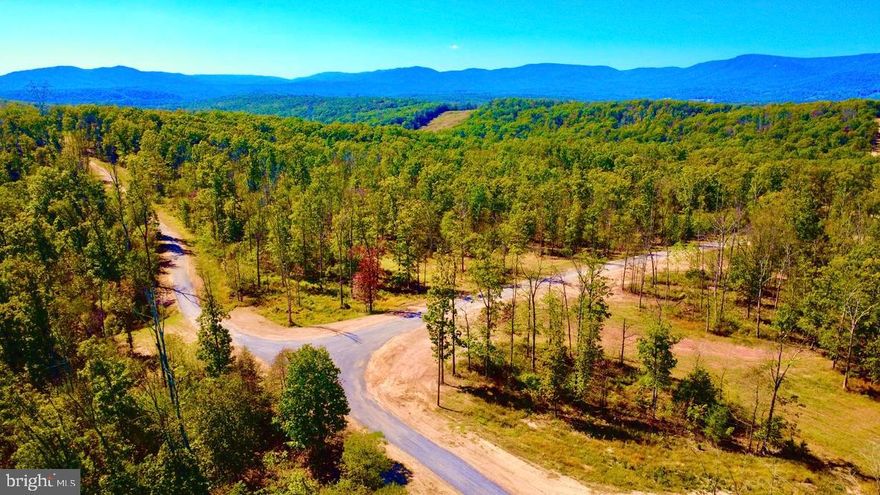 An unparalleled opportunity to own one of the most accessible yet private properties near the city of Winchester. Just under an hour and half from Dulles International Airport it is the perfect weekend escape in the countryside or full time residence. As you meander through the forest on the beautiful drive to the property you will become enchanted with your surroundings. This is one of 3 contiguous lots available in a unique subdivision, that has put the focus on something that can never be recreated, land and the freedom it offers. Experiencing the silence, pristine wilderness, and unmatched tranquility of this property is like owning your very own private park—an extraordinary rarity so close to the Metro DMV.
The closest neighboring residence to this parcel is currently over a mile a way, yet the seller has brought electric to the lots and perfectly engineered a road system to each lot. Each of three have unique characteristics;
 Lot 2 is one of the most exceptional of the three parcels in regard to the the seclusion and the jaw dropping views.  This is a must see to appreciate property. Imagine full seclusion that doesn’t require 4 wheel drive to access!  This exceptional, one-of-a-kind property is truly the one you’ve been waiting for—an extraordinary backdrop to bring your dreams and plans to life.  Encompassing 152.44 acres of pristine, unrestricted land, the property offers natural beauty and endless possibilities. A five-bedroom perc site for septic is approved, and a cleared building site awaits you at the end of an improved private driveway. The drive back to the building site opens to a stunning plateau with dramatic mountain views. The land features exceptional mature timber, along with healthy regenerative growth throughout the property. The property is currently enrolled in a professional forestry management plan, Offering environmental stewardship and long-term value the land use enrollment makes the taxes extremely affordable and provides excellent wildlife habitat. This is a true wildlife and nature lover’s paradise. Several wet weather and small year round streams meander through the acreage as well.  Whether you enjoy exploring, hunting, or simply sitting back and enjoying the peace and quiet, this property checks every box. There are countless miles of trails, including over four miles of professionally installed, all-weather improved road infrastructure, making the land easily accessible year-round. There is potential for a family subdivision. The property is ideal for a family legacy estate, retreat, winery, or a combination of residential living and agriculture or agri-tourism. The only limitation is your imagination.This offering is available as a single 152.44 acre parcel or as part of a larger package totaling 439.448 contiguous acres (see also VAFV2024650).Shown by appointment only.