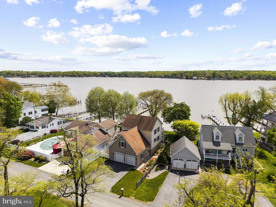 Rare Waterfront Retreat on the Elk River — Private Dock, Stunning Views & Room for Everyone
Welcome to this exceptional waterfront home in Elkton, where breathtaking Elk River views, a private dock with boat lift, and thoughtfully designed living spaces come together to create the ultimate riverfront lifestyle. Classic cedar shake-style siding, a paver walkway, and manicured gardens set the tone from the moment you arrive.
Inside, the dramatic great room impresses with soaring cathedral ceilings, hardwood floors, a granite-surround fireplace, and dual sets of French doors that frame stunning water views. The open floor plan flows into the dining area and a generous kitchen featuring wood cabinetry, a gas range, stainless steel appliances, a large center island with seating, and a built-in wine rack — perfect for entertaining.
The screened porch is the heart of the home — a window-wrapped retreat with panoramic river views and space for a full dining set. An open waterfront deck off the main level offers direct views of the dock and river, ideal for al fresco dining. Upstairs, the expansive primary suite features a private water-view balcony, walk-in closet, and a spa-like bath with freestanding soaking tub, tiled walk-in shower, and built-in vanity. Additional bedrooms include a charming queen guest room and a spacious third-floor bonus bedroom — perfect for family and guests. Upper-level laundry adds everyday convenience.
The oversized two-car garage includes an EV charging outlet, high ceilings, and covered storage underneath the deck for kayaks, paddleboards, and gear. Outside, the lush yard leads directly to your private dock and boat lift — ready for boating, fishing, or simply soaking in the river at golden hour.
This is waterfront living at its finest.