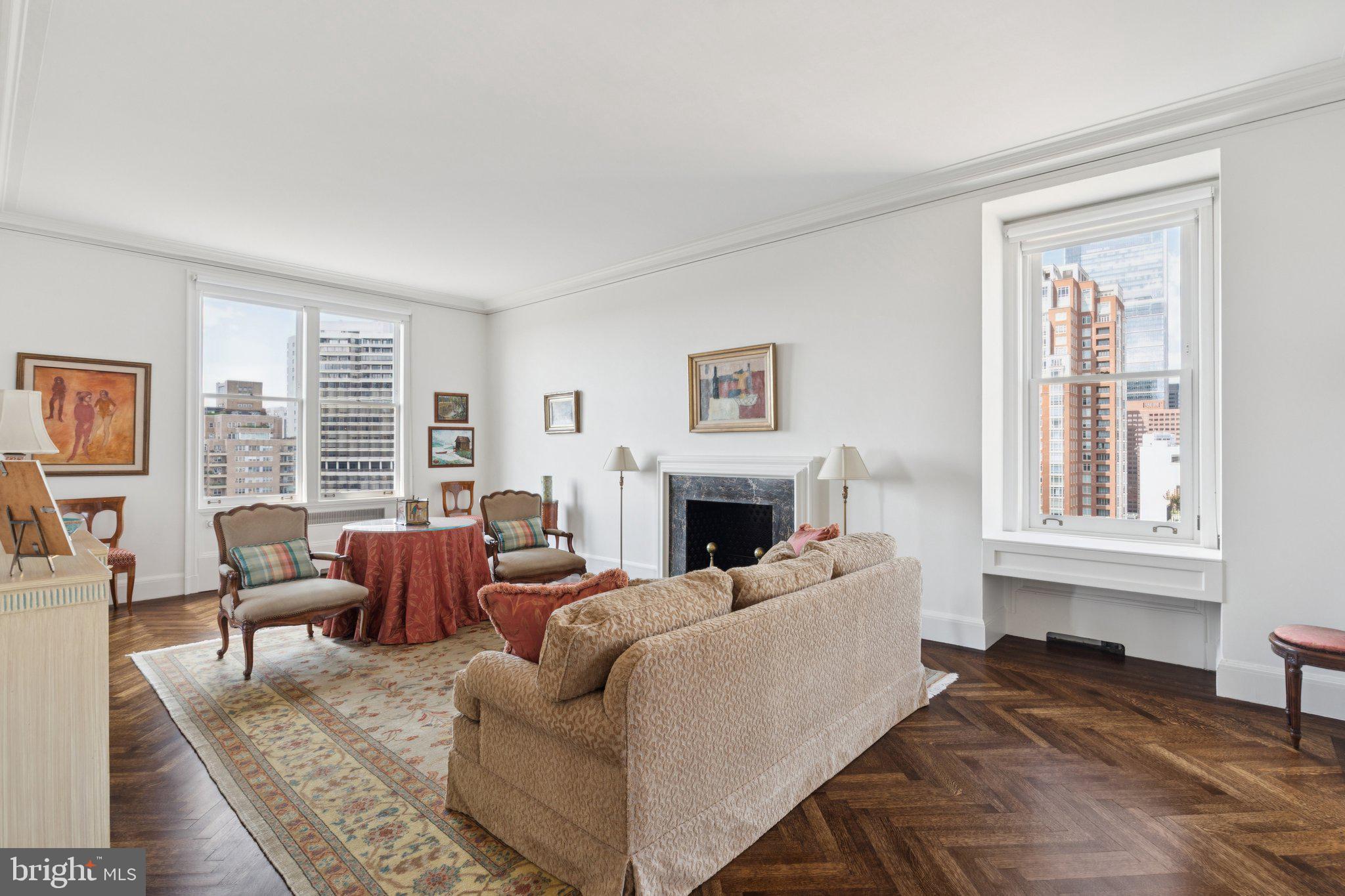 Meticulously maintained Barclay condominium overlooking Rittenhouse Square. This rarely available home at the highly coveted Barclay Condominium offers original architectural details, rich wood flooring, high ceilings, excellent entertaining space, and oversized windows showcasing panoramic views of the sunset over Rittenhouse Square, as well as sunrise views over the Center City skyline. Enter through a foyer with coat closet into a central gallery with parquet wood floors and a storage closet, ideal to be used as an entrance hall, alternate dining room or other entertaining space. Past the gallery is the expansive living room with two walls of tall windows offering views of The Square and a gorgeous fireplace with marble surround. Open to the living room is a grand dining room, perfect for hosting large dinners, with northeastern Center City views and a decorative fireplace mantle. Accessible from the central gallery and living room is a sun-soaked family room (or third bedroom) with another stunning fireplace mantle and direct views over The Square. The bright, eat-in kitchen features a breakfast nook with storage closet, white cabinetry with custom inserts, double stainless steel sink with disposal, large paned window providing excellent natural light, and a terracotta tile floor. Off of the kitchen is a butlers pantry with another double bowl stainless steel sink, glass-paned display cabinetry, white tile backsplash, and a stunning circular pendant light. Adjacent to the pantry is a bonus room that can easily be used as a home office, den or even a fourth small bedroom. It has a large window overlooking Saint Mark's Church, laundry closet with stacked washer/dryer, large wall closet, and ensuite bathroom with tub-shower. The incredibly spacious primary suite, currently being used as an office, enjoys more windows with Rittenhouse Square views, a deep wall closet, and an attached hallway with a large wall closet leading to the full bathroom featuring a tub-shower, white tilework, and another gorgeous pendant light. The second bedroom has two large windows overlooking The Square, a custom walk-in closet, and a sunny ensuite bathroom with tub-shower and custom tilework throughout. Additional home details include recessed lighting and custom light fixtures, herringbone and parquet wood floors, and handsome trim and moldings throughout. Residents at The Barclay enjoy a twenty-four hour doorman, fitness center, chauffeur driven Mercedes, on-site management, and individually controlled heating and air conditioning. Stephen Starr’s Barclay Prime steakhouse is located on the building’s ground floor.