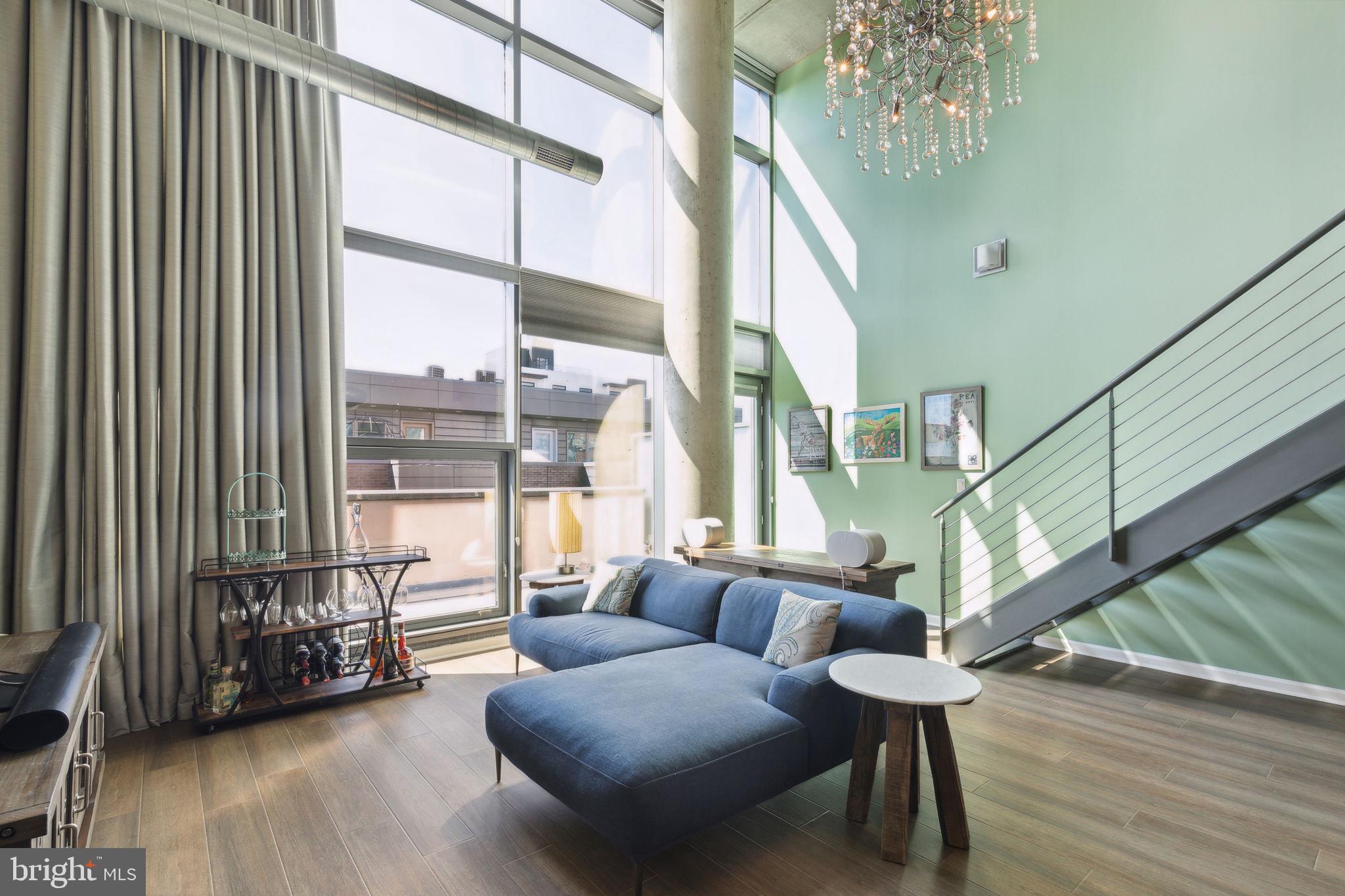 Upon entering this 2 bed 2 bath unit, you’ll immediately notice the spacious layout and impressive ceiling height. The open concept living area includes a modern kitchen with granite countertops, an island, a pantry, and plenty of cabinetry. Floor-to-ceiling windows flood the space with natural light, giving it an open and inviting feel. A bedroom on this level features custom closets, and there’s a full bathroom with a tub-shower combo for added convenience.
The large private patio is perfect for outdoor dining and relaxing.
Upstairs, the primary bedroom loft is so roomy that it offers the flexibility to also include a home office or gym. It features a walk-in custom closet with ample storage, along with space for a washer and dryer. The ensuite bathroom includes a sizable walk-in shower.
Additionally, this condo comes with a reserved parking space and two storage sheds for extra storage needs.
Close to Philadelphia’s Magic Gardens, the shops and restaurants on South Street, and easy access to public transportation, this is a must-see! Schedule your tour today!