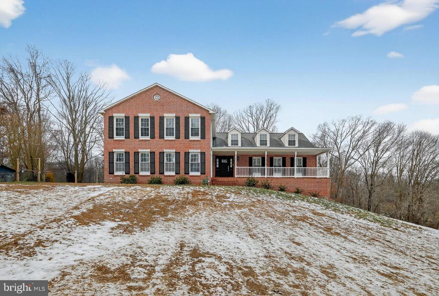 This stately brick-front home delivers space, style, and functionality across three fully finished levels. Set on a large, gently sloping lot in Huntingtown, MD, this 4-bedroom, 3-bathroom property combines classic charm with modern living. 
All 4 generously sized bedrooms occupy the upper level, creating a private sanctuary away from the main living areas. Bathrooms are strategically positioned across all 3 floors for everyday ease: a full bath in the finished basement, one on the main level, and one upstairs.
The main level showcases an open-concept living, dining, and kitchen area flooded with natural light, polished hardwood flooring, and direct access to the expansive sunroom—a bright, airy space overlooking the backyard. The kitchen features updated white cabinetry, stainless steel appliances, and a center island that works equally well for everyday meals or entertaining guests.
The finished walkout basement offers exceptional versatility with a full second kitchen, spacious living area, and full bathroom, designed for in-laws, guests, or even rental income. Double doors open to the backyard, where ample space awaits outdoor enjoyment throughout the seasons.
Additional highlights include a full-length covered front porch with room for rocking chairs and seasonal décor, an oversized 2-car garage withe clean floors. There’s also a bonus storage space, and a wide driveway. Fresh paint throughout and upgraded lighting fixtures add a polished touch. The expansive backyard offers privacy and serenity.
Located a short drive from local shops, schools, and major commuter routes, this home balances peaceful surroundings with everyday accessibility. For multi-generational living, rental flexibility, or simply more square footage, this residence delivers on every level. Literally. "It has the detached workshop that is more than 700 square feet."