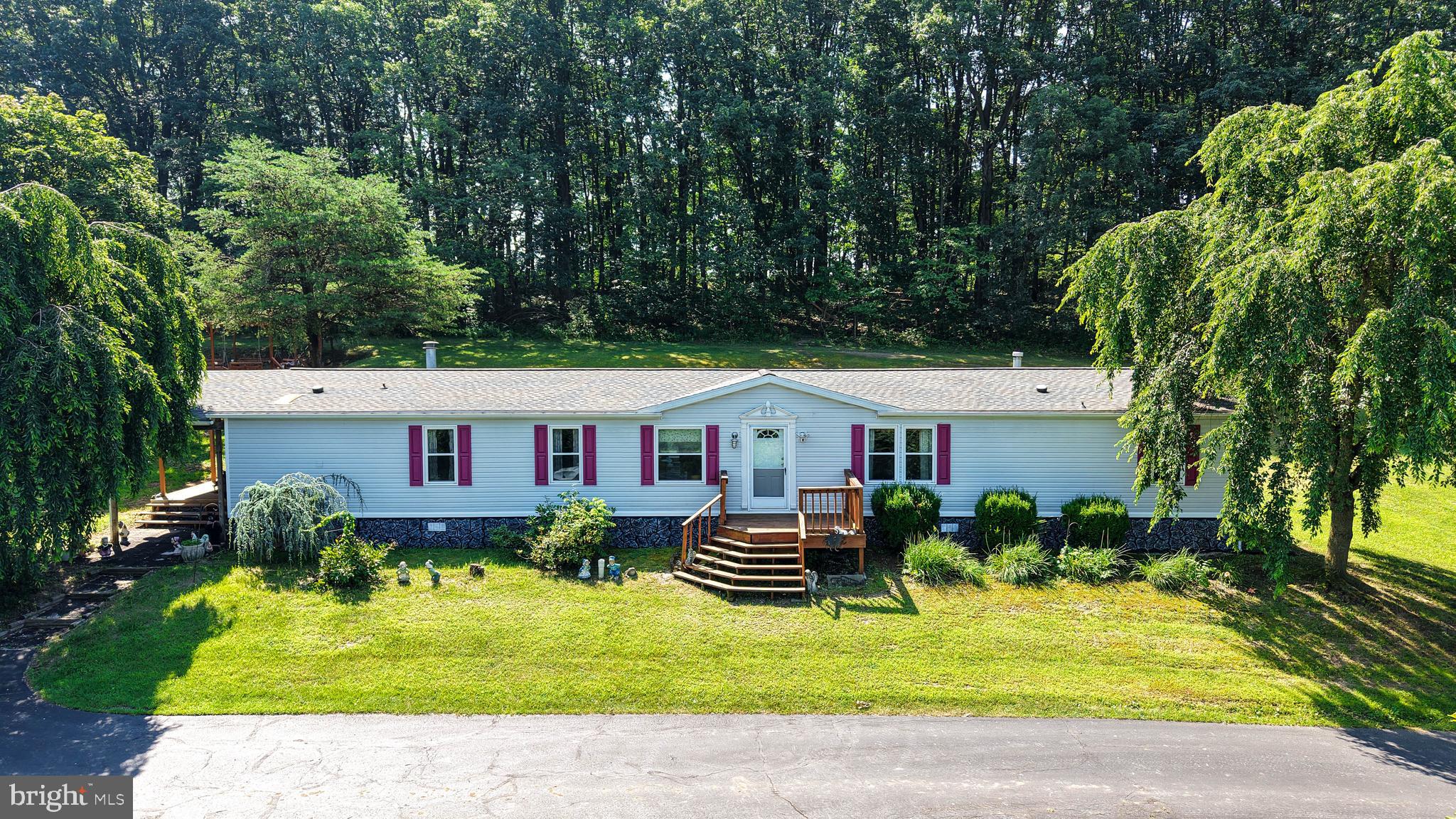 Public Auction Saturday September 6, 2025 @ 12:00 pm. Open House Saturday August 30th 1-3 pm. Successful bidder requires a 10% non-refundable deposit. Settlement within 45 days. Buyer pays the 2% RE transfer tax. List price does not reflect the final sales price. You are not going to want to miss this!! This property will check off many boxes. A large, 4 bedroom, 2 full bath plus much more, double wide mobile home situated on a serene 2.26 acres surrounded by trees and farmland! Once you drive up the long macadam driveway to the home, you will notice the ample parking area, the large 24 x 30 detached garage, two sheds, a large wrap-around porch, a beautiful setting, and of course, the fire pit with swings! This property is perfect for raising a family and having gatherings for friends and family! There is no shortage of space with this beautiful property.
As you enter this home, you will be pleasantly surprised with the spacious living room, which has ample space for plenty of furniture and entertaining. Large windows flood the house with natural light. With an open floor plan, the dining room/kitchen features stainless steel appliances and a bar stool counter top for extra seating. From the kitchen, you will enter the morning room, a room filled with even more natural light from the skylight above. It's a quaint room that can be used to relax and enjoy the quiet of the morning, as a breakfast nook, or for meal preparation with the convenience of the walk-in pantry nearby. Next to the morning room is the second living room! The beautiful stone propane fireplace being the focal point of this room. This is a wonderful room to sit in on a cold winter day as you watch the snow fall through the large windows while cozying up to the warmth of the fireplace. The primary bedroom is located on one end of the home and includes a large walk-in closet and a master bath featuring a double sink long vanity, a garden tub and a stand-up shower. There is an additional room off of the primary bedroom that could be used as a den, office, additional storage or extra closet space. There are 3 bedrooms and a full bath located at the opposite end of the home with adds comfort for guests. The mud room/laundry room is conveniently located right inside the side door. This house has been well-kept and comes with a Generac generator, laminate flooring throughout the main living area, an onsite well and septic which means no water or sewer bills! Being sold as is. The shed to the right of the house when facing the house is not included with the sale. There is no title. The title has been canceled since it is permanently affixed to real estate. This is a deeded property. We have a form from PennDOT clarifying this. Being sold as is.