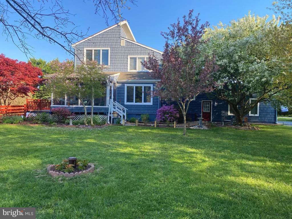 Rare opportunity. Custom home located in the beach front community of Cove of Calvert. Less than a block from the Chesapeake Bay. Neighborhood path leads to the picnic tables and the beach, where you can still find fossils and other seashells. This contemporary home sets on a scenic .63 acre corner lot. that has meticulously kept. From the 1,200 square foot 4 car garage, a walkway surrounded by luscious plants leads you to the screened in porch and to the front door. Formal living room and family room have hardwood floors. The open concept floor plan makes it an ideal home to entertain in. The kitchen with ceramic tile, boasts custom solid hickory cabinets, glass top display on kitchen island and stainless steel appliances. The family room has a pellet stove with a floor to ceiling stone hearth that keeps the entire house warm in the winter, saving money on heating bills. Primary bedroom located on the main level has hardwood floors, walk in closets and walks into a newly renovated full bath with ceramic tile, oversized shower and custom vanity. The laundry room has extra storage for all those things you want to keep out of the way. A spacious sunroom can be used for a dining area, home office or whatever you like. It walks out to a 2nd screened in porch that leads to the fenced in backyard with mature trees and lots of green grass for the kids or puppies! Upstairs are 2 bedrooms and a 1 full bath. The bath has been recently renovated with a beautiful ceramic tile shower and incorporated in the shower is stained glass panel made by a local artist. 3 steps up from this level is a huge bonus room lined with windows expounding on the open views. This room can easily be made into a 4th bedroom or have a separate rec room / media room, you name it! The exterior of this home has been recently remodeled with top of the line Certainteed siding. Both HVAC systems have been replaced within a year. Come see this fabulous home on the park like setting!!