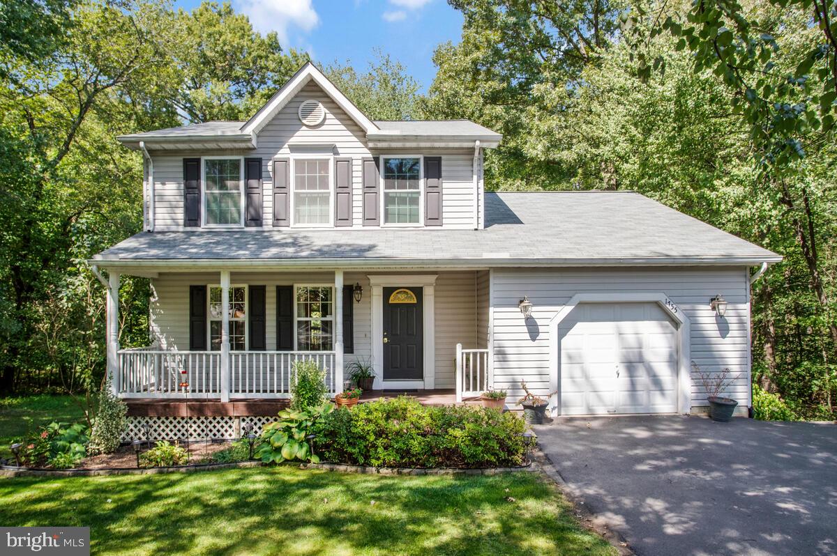 Welcome to this stunning colonial, perfectly blending a peaceful country ambiance with the convenience of nearby amenities. Situated on a cul-de-sac and backing onto tranquil wooded land, this property offers both privacy and easy access to BWI Airport, Fort Meade, Maryland Live!, shopping, and dining. From the expansive front porch, step inside to an open floor plan with a spacious living room, family room featuring a wood-burning fireplace and vaulted ceilings, a beautifully remodeled kitchen boasting quartz countertops, a spacious island, custom backsplash, and updated appliances, which opens to a large dining room, all with beautiful hardwood floors. Updated half bath on main level. The primary bedroom is a true retreat with its vaulted ceiling, ample closet space, and a renovated en-suite bath showcasing a large vanity, elegant tiled walls, and a walk-in shower with a frameless door. An additional updated full bath and two more bedrooms complete the upper level. The finished walkout basement offers versatility with a bedroom, large rec room, wet bar, built-in speakers, and a laundry room equipped with an extra refrigerator. Step outside to enjoy the serene surroundings from the fabulous decks and patio—ideal for relaxing or entertaining. Extra-wide driveway allows for parking of up to 4 cars. New roof installed in 2023. Water heater and heat pump have been updated as well.