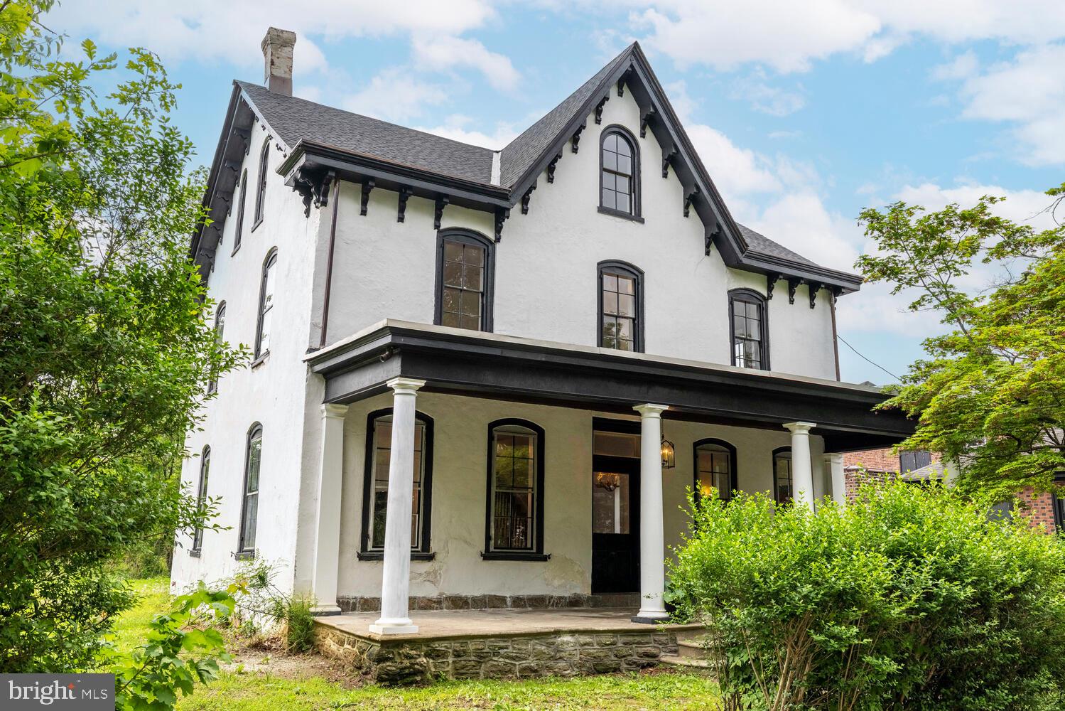 Step back in time—without sacrificing modern comfort—in this remarkable ca.1866-built home, steeped in local history and architectural character. The Gothic Revival and Italianate style house was built as part of the development of the Chew Estate, where the Battle of Germantown took place during the American Revolution. In fact, the house sits on one of the "Battleground Lots". The first owner was Catherine Price, who was a "Dunker," a moniker for adult baptism in the Church of the Brethren. The second owner was Samuel Harting, an important local builder, bought the house in the early 1900s, at which time he made his mark with a sweeping renovation that brought the house into the modern age of its time. He even constructed the striking brick building next door as his personal office—a decorative gem designed to showcase his craftsmanship.
Today, the home still stands as a testament to quality and care across centuries. Cross the wide front porch and enter through the original front door into a gracious formal foyer. To the right, a massive front parlor welcomes you with soaring ceilings and an original gilt mirror that’s seen generations pass through its reflection. Across the foyer, the dining room lies just ahead, accented with built-in cabinetry that feels both timeless and intentional. Antique oak floors run throughout the first and second floors, grounding the home with warmth and history.
In the rear of the home, you’ll find a smartly updated kitchen, a convenient powder room, and a laundry room with first-floor access—offering 21st-century ease within a 19th-century shell. Upstairs, the second floor features four bedrooms and two full bathrooms. One bath retains its antique soul, boasting original tile work and mirrors, while the other—a sprawling, luxurious space—anchors the primary suite. The third floor offers two more spacious bedrooms and a massive storage closet, easily adaptable to your needs.
The home has been thoughtfully maintained, with major updates where they count, including a new main roof in 2021 and central air throughout.
An easement provides access for off-street parking via the neighboring driveway (currently unpaved)—simply drive through to park in the backyard, where the original carriage house still stands. The carriage house has its own deed and is available for purchase in addition to the main residence, offering exciting possibilities for studio space, guest quarters, or future development.
This is not just a home—it’s a piece of Germantown’s living history, lovingly updated and ready for its next steward. Please note listing agent has a financial interest in this property.