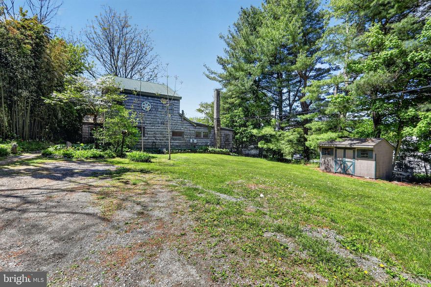 Set on a peaceful lot in the beautiful rolling hills of East Fallowfield Township, this circa-1880 home blends rustic character with flexible living space and unique outbuildings. This property is perfect for handy buyers or contractors with the skill and resources to make the most of all this property offers. Beyond the main house, the property includes two additional structures with exciting potential. A small cottage with a full bath, kitchenette, and sleeping loft, is currently rented by a long-time tenant, offering income opportunity, though it would benefit from updates. The cottage and main home share the well and septic.  A larger two-story outbuilding provides a blank canvas for an artist’s studio, workshop, or creative space, but will require significant restoration to bring it back to full functionality. Clad in classic cedar shake siding and topped with a durable metal roof, the main home is reminiscent of a New England saltbox or English cottage, particularly with the surrounding gardens and pretty stone patio. You'll notice, as is typical with older homes, there have been additions over the years, reflecting the house's historic roots while offering room to make it your own. A sweet stone walkway leads to the front door and convenient vestibule entry. Kick off your shoes and leave your umbrella before you enter this warm and welcoming home. Inside you'll find rich wood flooring throughout and a spacious layout. Begin in the large living room anchored by a cozy wood stove, perfect for large gatherings of family and friends or a quiet evening at home. The generously sized kitchen with a peninsula opens up to the dining room ideal for hosting and everyday use. They share a very pretty built-in cabinet along one wall and the dining room boasts a whimsical mural (paper) and French style doors out to a stone patio. Pull up a stool at the peninsula for a quick breakfast or to chat with the cook. This floor also includes a main level bedroom with a very cute reading nook, a relatively new full bathroom that shares space with the convenient main floor laundry room and a flex room for an office or playroom with a slider to a small deck. Head upstairs to the generously sized primary bedroom, a second bedroom with built-in shelving and 2 small closets and a full hall bath with shower. In the hallway, is a large closet to service the primary bedroom and bright desk area for sewing, crafts, or a homework station. The finished attic is currently used as a bedroom, but alternatively offers excellent space for storage or a flex room. There is a partial, dirt floor utility cellar and crawl space accessed from the outside. The home is heated by a propane forced-air system serving the main floor, with passive heat rising to the upper level. The wood stove offers additional heating and there is a tankless hot water system powered by propane. Most windows have been replaced over the years. Surrounded by gorgeous Chester County horse country (views of pastures across the street) and within a short drive to The Laurels Preserve for hiking, Plantation Field Horse Trials which hosts a multitude of events, Longwood Gardens, West Chester, Unionville and Kennett Square, Parkesburg or Thorndale for everyday shopping, Triple Fresh Market for a quick lunch and the new Doe Run Elementary School. With its historic charm, versatile layout, and opportunity for improvement, this property is well-suited for those looking to invest, create, or simply enjoy a distinctive home with character.