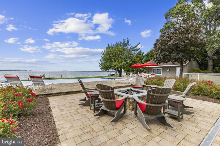 Welcome to waterfront luxury living in the coveted golf course community of Prospect Bay. This one-level home combines timeless design, modern updates, and resort-style amenities on 1.39 acres. With water views from nearly every room, breathtaking sunset views, and beautiful landscaping throughout, every moment at home feels like a retreat.

The heart of the home is an entertainer’s dream—an open-concept living area featuring a propane stacked stone fireplace, expansive windows, and seamless flow to the outdoors. The gourmet kitchen is fully updated with an oversized island, 8-burner stove, and top-of-the-line appliances, while the adjoining living space opens to a patio designed for al fresco dining and sunset views. A bright sunroom with floor-to-ceiling windows frames the poolside fire pit, perfect for gathering with family and friends.

The primary suite is a private sanctuary with floor to ceiling windows offering water views, direct deck access, a walk-in closet, and a spa-like bath with dual sinks. Two additional spacious bedrooms in the main house share an updated hall bathroom. Guests are equally pampered with their own detached cottage—complete with bedroom, bathroom, kitchenette, and private patio overlooking the water.

Outdoors, the amenities rival a private resort. A spacious deck leads to a 20x40ft infinity pool, a hot tub and sweeping Bay views, while a private pier with a 10,000lb lift the potential for endless boating adventures. The lush landscaping provides both beauty and privacy, with mature trees offering the perfect balance of sun and shade. 

Additional features include a two-car garage with ample storage and workshop space, laundry area off the garage, and multiple indoor/outdoor living spaces designed for both relaxation and entertaining. This is more than a home—it’s a lifestyle of elegance, comfort, and waterfront tranquility in one of the area’s most sought-after communities. Prospect Bay is the premier golf community on the Eastern Shore offering 18-hole course, pickle ball, tennis, private clubhouse with restaurant and bar, driving range, pool, and more!