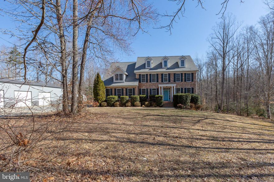 Exuding brick stateliness... nestled on 7.99 serene acres... and a total back yard utopia with a lagoon pool like few others? Prepare to be totally captivated by 9021 Ellis Lane in Spotsylvania County! The property is zoned agricultural (A-2), so you can bring your horse(s), too! The back yard also includes a huge deck, 1,800 square foot patio (with a 12x4-foot bar) and... a 40,000-gallon lagoon pool (added in 2023!) complete with a sun deck, buddy seats with jets, diving board and LED lights! Other outbuildings include a 12x16-foot shed and... the 3,000 square-foot, detached garage (built in 2024!) with a connected lean-to (12 feet in length!). With 3 pull-in bays, a wood stove, concrete flooring and so much more, this is primed for a car lift, workshop, man cave and so much more! For extra parking, there’s also an attached two-car, side-load garage on the main residence. Under its current owners’ stellar care for the past decade, this home includes five bedrooms (all upstairs), 3.5 baths and 3,173 square feet of finished space on its two above-ground levels. It sits on a mature hardwood-draped, no-HOA lot in the Estates at Roberts Pond community. The neighborhood features tranquil, larger lots making for quite the vibe. As for the acreage here, the home is tucked off a private paved road, with a long driveway segueing to the homesite. Wildlife abounds – on a given day, you can see white-tailed deer, turkey and more. Along the back edge of the property, there are walking and 4-wheeler trails, natural springs, hunting stands and more outdoor bliss.  Back to that main residence, it has a brick front, cream siding, teal door and forest green shutters. Heading inside, you’re greeted with gleaming hardwood floors, a massive open foyer and open spaces aplenty. Main level highlights include a home office with built-ins; formal living room and dining room with unique glass window entry; half bath; family room with center gas fireplace and ample cabinetry/built-ins; mudroom with built-ins; and the kitchen! The kitchen includes a desk/cabinetry, granite countertops, medium maple cabinetry, a sizeable central island with cooktop and black GE Profile appliances. The kitchen also has an eat-in space with sliding glass access to the deck paradise. Upstairs are five carpeted bedrooms as well as three baths. The primary suite includes a large walk-in closet (note the built-ins!), a sitting nook and ensuite bath complete with a jetted garden tub with adjacent windows, a standup shower, two sinks and a separate vanity area. Of the additional bedrooms, one has an ensuite bath and walk-in closet. Two of the additional bedrooms share a Jack-and-Jill bath set-up. We have an unfinished basement here, too! It spans approximately 1,500 square feet and is drywall ready, inclusive of rough-ins for a bathroom. Unfinished, it’s perfect for a home gym, office, possible recreation room, storage and... you name it! There is a new sliding glass door exit. Component-wise, the home’s hot water heater, HVAC and systems have all been regularly maintained. Location-wise, the residence is within 10 minutes of grocery, shopping and dining selections along Route 3. I-95 access (Route 3 exit) is within 20 minutes and the Massaponax exit (as well as more grocery, shopping and dining options) is within 25 minutes. The heart of Downtown Fredericksburg is within 25 minutes northeast! If space and tranquility are high on the list, prepare to be wowed inside and out here!