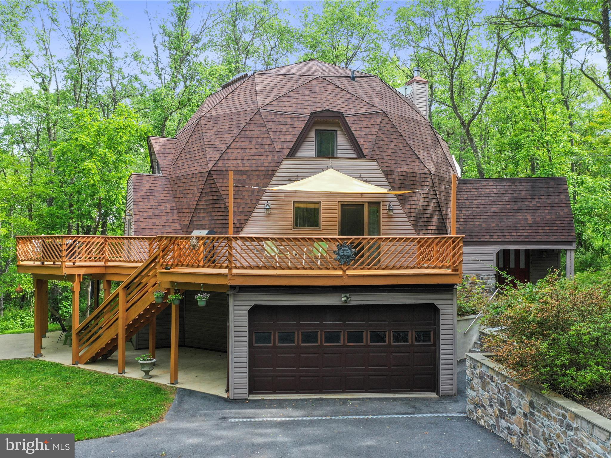 This rare opportunity is hard to find. Due to another buyer's inability to move forward with closing could be YOUR gain! If you've been waiting for something truly extraordinary, welcome to 11035 Bennie Duncan Road-an architectural gem nestled on nearly 19 acres of peaceful, wooded paradise just outside of Frederick. This custom-built geodesic dome home is as functional as it is captivating, offering nearly 3,000 square feet of sun-drenched living space, panoramic nature views, and room to breathe both inside and out. Step inside and discover a layout that feels refreshingly open yet wonderfully cozy. With 4 bedrooms, 3 full baths, and versatile spaces including a loft, bonus room, and finished walkout lower level, there's flexibility for every lifestyle-whether you're working from home, hosting guests, or simply enjoying quiet moments surrounded by nature. The heart of the home is the expansive great room, where warm hardwood floors and a central wood stove invite you to linger. The updated kitchen features stainless steel appliances, ample cabinetry, and connects effortlessly to multiple gathering areas. Slide open the doors to a truly magical outdoor experience: a sprawling wraparound deck perfect for grilling, stargazing, or spotting deer among the trees. Below, a covered patio with fans offers a breezy, shaded retreat on warm summer days. A separate patio with electric hookup for your hot tub provides the perfect setting for fireside chats and s'mores under the stars. Tucked deep into the trees with a private stocked pond, the property is a nature lover's dream-whether you're exploring the trails, hunting, enjoying the peace of your private acreage, or envisioning your own piece of paradise. Additional highlights include a barn/detached 6 car garage (tandem), a spacious upper level area with private entrance. Homes like this don't come along often. If you crave privacy, style, and a deep connection to the land-without sacrificing proximity to major conveniences-11035 Bennie Duncan Road is your rare chance to have it all.