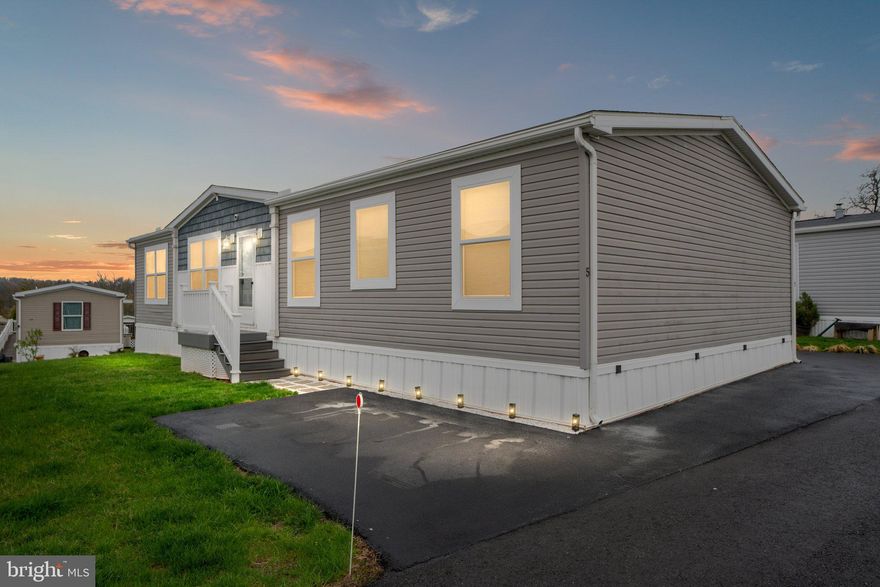 Welcome to 2917 Unit 5, a well-appointed raised ranch-style modular home located in Lower Pottsgrove Township, this 3-bedroom, 2-bath property is part of the well-maintained Wind Haven Mobile Home Park.
The open-concept layout features a combined kitchen and dining area with modern vinyl plank flooring, recessed and pendant lighting, and a large eat-in island. The kitchen includes an electric stove, oven hood, refrigerator, dishwasher, double sink, and a large walk-in pantry for ample storage. The primary suite features a ceiling fan, walk-in changing room, and a spacious bathroom with a double-sink vanity, soaking tub, and separate shower stall. Two additional bedrooms offer wall-to-wall carpeting and generous closet space, with a full hallway bath that includes a tub/shower combo. The living room is designed for everyday comfort with built-in shelving, an entertainment center, ceiling fan, and vinyl plank entry. A flexible bonus room offers space for a laundry area, workshop, or home office and includes both washer and dryer. Outdoor living is made easy with a composite deck and retractable awning, a side yard, and two off-street asphalt parking spots. The home features central air, electric heat pump with forced hot air, and 200 AMP electric service. Water and sewer are included in the $650/month lot rent, along with snow removal and road maintenance.