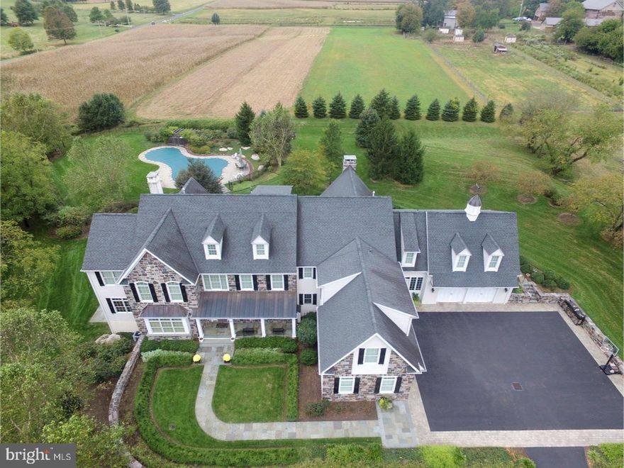 Exquisite stone front estate built by Mack and Roedel Custom Builders in the Upper Makefield community of Ely Farm. No detail has been overlooked in this gorgeous estate. Enter to the formal foyer with coffered ceiling, crown moldings and wainscot. To the left is the formal living room with custom moldings and French Pocket Doors leading to the Billiards Room / Conservatory. This room boasts wainscot paneled walls, beamed ceiling, chandelier and walls of windows allowing for plenty of natural sunlight. Adjacent is the handsome study with custom built ins, wainscot walls, sitting area and fireplace. The formal dining room also features a coffered ceiling, custom low lighting, custom built ins with access to the Butler's Pantry.  The large kitchen features premium stainless steel appliances, raised panel custom cabinetry, granite countertops large center island/breakfast bar with custom pendant lighting above, and desk area. Adjacent is the sun drenched Morning Room with atrium doors to rear patio. The 2 story family room features a stone fireplace, wall to wall custom built ins and coffered ceiling with chapel beams. The breezeway allows for an informal entry from the garage areas, featuring ceramic flooring, powder room, access to both garages and elevator. Accessing the Grand Stairway will lead you to the exquisite Master Suite with plush carpeting, coffered ceilings, sitting room, 2 large walk in closets, luxurious master bath complete with Jacuzzi, double shower with multiple custom shower heads, double vanity and marble flooring. This level features 4 additional bedrooms all with private baths. Also on this level is access to the au pair suite / in law suite, complete with bedroom, kitchenette, living room and full bath. Lower level features custom built bar, wine cellar, game area, media room with custom built entertainment center, exercise room, full bath, access to the elevator and plenty of unfinished storage area. The third level features a bonus room/loft. The exterior boasts 5 car garage, stone retaining walls, custom walkways and patios, perfectly manicured gardens, hot tub and custom in ground pool. Perfect retreat for entertaining!