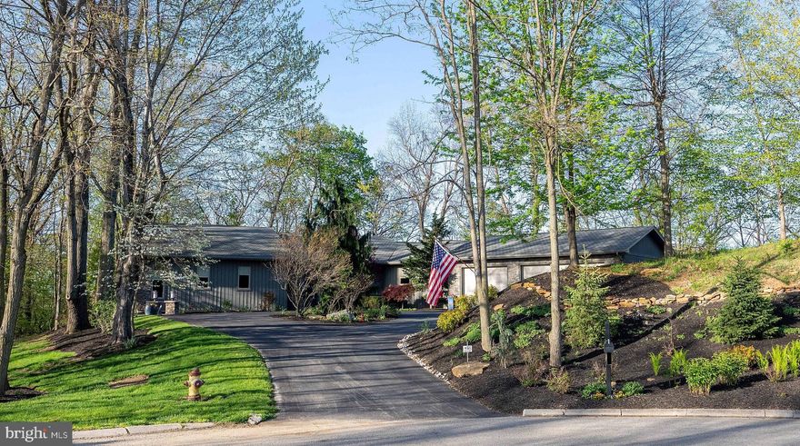 Tucked into a serene wooded lot, this stunning contemporary home offers the perfect blend of modern design and natural beauty all sitting on almost 2 acres at the end of the cul-de-sac. The open floor plan, covered with slate and bamboo floors, creates an inviting and seamless flow between the living, dining, and kitchen areas, all filled with natural light from expansive windows that frame the surrounding trees. Clean lines, vaulted ceilings, and quality finishes give the space a fresh, airy feel. This contemporary kitchen is the heart of the home, featuring a sleek and functional design perfect for everyday living and entertaining. A large island bar with seating invites casual dining and conversation, while the gas cooktop and modern black stainless-steel appliances offer both style and performance. The kitchen flows seamlessly into the vaulted living room, where vaulted ceilings and a striking stone gas fireplace create a warm and inviting atmosphere that overlooks the patio area. Just a step down, a spacious family game room awaits—ideal for gatherings, play, or movie nights—making this open-concept layout as versatile as it is beautiful. The private master bedroom suite offers a peaceful and spacious escape, designed with both comfort and function in mind. The room easily accommodates a king-size bed and additional space for a sitting area - perfect for reading, unwinding, or enjoying your morning coffee. A highlight is the oversized walk-in closet, providing abundant storage and organization options. The adjoining master bath is equally impressive, featuring a dual-sink vanity, jet tub, separate step-in shower, and private water closet for added convenience and privacy, making this suite a true haven within the home. Three private bedrooms offer comfortable and secluded retreats, perfect for guests or family members. One bedroom features its own en-suite bath with a step-in shower. The home office offers a serene and productive environment, enhanced by a full wall of built-in cabinets and shelving that provide ample storage and display space. The abundance of windows frame peaceful wooded views, bringing in natural light and creating a backdrop for focused work or creative inspiration. The combination of functionality and scenic beauty makes this space ideal for remote work, study, or quiet retreat. This home offers exceptional storage throughout, thoughtfully designed to keep everyday living organized and clutter-free. The huge laundry room is no exception with not only an abundance of cabinetry, but an island workspace, and sink. It also serves as an entrance from the oversized 3 car garage which boasts radiant heat and storage units. Step outside to discover a thoughtfully designed hardscape entertainment area—ideal for hosting gatherings or relaxing in solitude. Surrounded by the sounds of nature, this outdoor retreat features a stone patio, built-in gas fire pit and grill/bar area, creating an effortless extension of your living space into the great outdoors. The property features top-tier mechanical systems, including four-zone radiant heat, central air conditioning, central vacuum, and pre-installed generator connection for added peace of mind.