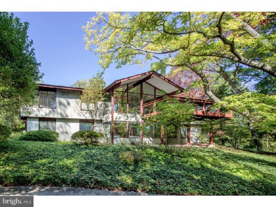 New Professional photos to come-  Modern elegance and expansive living spaces define this exceptional six-bedroom estate by renowned builder Robert McElroy, privately set on 3.83 acres and featuring a SEPARATE GUEST HOUSE.

Beyond the gated entrance, a long, winding drive leads to a sophisticated yet understated residence highlighted by soaring ceilings, walls of glass, and rich wood accents throughout. A dramatic glass atrium-style reception hall with slate flooring creates a striking first impression. The stunning living room boasts a vaulted ceiling and an impressive window wall, filling the space with natural light and offering serene views of the surrounding landscape.

The adjacent dining room, also with a vaulted ceiling and glass walls, provides seamless access to a wraparound deck—perfect for indoor-outdoor entertaining. The gourmet, center-island kitchen is a true showpiece, featuring exotic wood and stainless steel cabinetry, Blue Macaubas granite countertops, honed limestone floors, with premium appliances. Glass doors lead directly to the deck and pool area.

A bright breakfast room with floor-to-ceiling windows connects the kitchen and family room, complete with custom built-ins. The main level is further enhanced by a luxurious primary suite offering a private sitting room, walk-in closet, and a sleek, spa-like bath.

The lower level includes five additional bedrooms, 2 bathrooms, a laundry room, and a spacious recreation room with multiple windows and sliding glass doors, providing direct outdoor access.

In harmony with the main residence, the guest house (built in 1990) offers approximately 1,000 square feet on the upper level, which could be used as a spacious home office with a sink, dishwasher, refrigerator, powder room, and access to a private deck through sliding glass doors. The lower level features an exercise room, full bath with shower, and a one-car garage.

Additional highlights include a two-car attached garage, a whole-property generator servicing the home, guest house, and front gate, and beautifully landscaped grounds with mature trees. The resort-style swimming pool creates a private outdoor oasis, ideal for both relaxation and entertaining.

A rare offering combining architectural distinction, privacy, and luxury amenities.