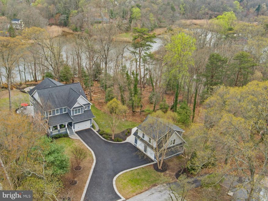 This stunning four-story Craftsman-style waterfront home is perfectly positioned on the serene shores of Deep Creek, blending timeless elegance with modern comfort. Step inside to 9'+ ceilings and exquisite details, including coffered ceilings and rich wood floors. The main level features a spacious office/bonus room upon entry and the open floor plan houses the gourmet kitchen with large island, pantry, breakfast nook, a formal dining room, and a cozy living room with a fireplace—all with captivating water views. A conveniently located powder room and mudroom with laundry adds to the home's functionality. Designed for entertainment and relaxation, the lower level boasts a theater room, a welcoming family room with a fireplace, a full kitchen, a bedroom, a full bath, and a laundry/storage room. The walk-out stairs makes for easy access to the stunning backyard and waterfront. The upper level is home to four bedrooms and three baths, including a luxurious primary suite with a coffee bar, two walk-in closets, and a sunroom with panoramic waterfront views. Unwind in your private hot tub and sauna, or utilize the adjacent flex room for endless possibilities. The additional bedrooms include a guest suite with an ensuite bath and two bedrooms sharing a well-appointed bathroom. On the top level, an open-concept space with a kitchenette and full bath provides a versatile area for a guest suite, game room, or private retreat. Outdoor living shines with multiple patios, a firepit, an outdoor fireplace, and a private pier extending into Deep Creek with quick access to the Magothy River and the Chesapeake Bay. The finished detached 2-story garage features an au-pair, guest suite and/or indoor studio. Great additional space to accommodate an overflow of visitors! With 45 feet of waterfront, stunning craftsmanship, and luxurious amenities, this exceptional property offers a rare opportunity to enjoy waterfront living at its finest. Located in the award winning Broadneck school district and close to restaurants and shopping this is the perfect location to enjoy everything the area has to offer including easy access to RT 50 and beyond.  Welcome Home!