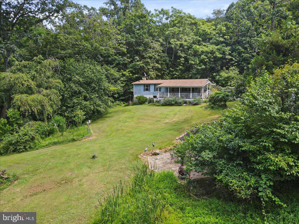 Welcome to YOUR private SANCTUARY! Over TWENTY TWO (22) Acres of Nature, making this the PERFECT Escape for ANY Outdoor Enthusiast, YOU Heard RIGHT- (22)+ AC!! If you simply want PRIVACY & GREAT VIEWS, this home is a DREAM! Need Ease of Effort??- One Level Living!! (Speaking of PEACE of MIND)- The Views aren't the ONLY peaceful aspects of this home! Enjoy knowing your ROOF, HVAC, and WATER HEATER are LESS than TWO (2) years old!! NEED MORE?? Personalize the home and Create ANYTHING in the unfinished, WALK-OUT basement that spans over 1,000 sqft. It's waiting FOR YOU (but not in a creepy way!) to make YOUR VISION come to Life! Looking to TINKER, HOBBY, or just GET DIRTY?! Do NOT fear, Wonder Whitney is HERE with what YOU NEED!! This property also features a WORKSHOP that is currently being used as a Creative Art Studio & Brilliant Work Station, but you can TRANSFORM it as you WISH! WANNA CUDDLE?? (Cuddles NOT Included in Sale, hehe) BUT what IS Included, is not ONLY (1) Cuddly Warm-Inviting Woodstove, BUT (3)!!! – Every Building is Outfitted with a Woodstove – so Pick a Cuddle Zone of your Liking and Beat the Chill! MEANING, YES- You can also tinker and hobby YEAR-ROUND too! BUT WAIT, there's EVEN more!! This property Actually Features TWO (2) septic systems – So, Make YOUR Homestead Grounds; Bring the FAM!! Endless Possibilities at your Fingertips!!!...and if Nothing Else, you will Never Forget the Beautiful Surreal Drive back the Lane, Welcoming Nature as Nature Welcomes YOU!! We Welcome YOU Home!!