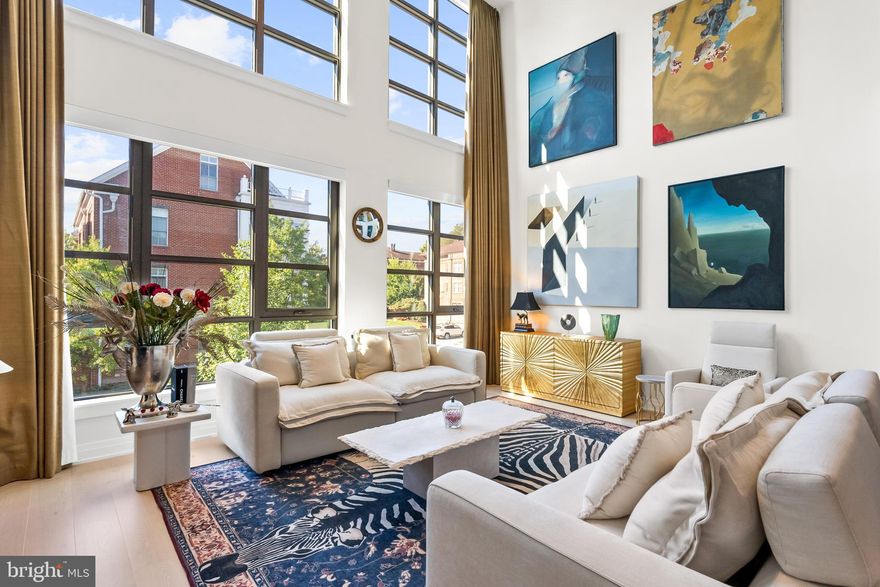 A rare find in one of Old Town’s premier waterfront condominiums! Dramatic 19' ceilings, light filled and refined, this two-story, 1 BEDROOM, DEN PLUS LOFT, 1.5 bathroom, 1,665 sq. ft. residence is framed by exquisite details, oversized two-story windows, 7.5” wide oak wood floors and MANY UPGRADES.  Located in a special "wing" of the building shared with just 2 other residences, this home is designed for the discerning chef: the open-concept kitchen showcases sophisticated Italian Snaidero cabinetry, Bosch appliances, and quartz countertops—complete with an island featuring deep storage drawers, counter seating, and a built-in wine cooler/beverage refrigerator. Dramatic floor-to-ceiling windows with automatic shades and custom drapery in the two-story living room,  flood the home with natural light. An upper level loft is perfect for lounging and a home office and is equipped with California closet built-ins and laundry closet. Unwind in the private primary suite, highlighted by custom walk-in closets, and a spa-inspired bath boasting a dual-sink vanity, LED backlit mirrors and Waterworks fixtures. A spacious den which is currently used as a large walk-in closet made by California Closets, is also perfect for a home office or extra bedroom. Upgrades in the home include high quality bevelled mirrors in the bathroom  and closet doors, new elegant finishes, a show-stopping chandelier that accentuates the main level's 19-foot ceilings; the home will also wow you with thoughtfully designed custom closet systems featuring gleaming rods, integrated dresser drawers, smart shelving, and useful hooks - maximizing storage in the primary suite and guest bedroom/den. Included with this residence are two rare perks for condo living: A sizable storage unit and two deeded garage parking spaces with prime location, delivering a true lock-and-leave lifestyle. Meanwhile, Muse pampers residents with top-tier amenities: a 24-hour concierge, on-site manager, and building engineer ensure an easy living experience, while the penthouse clubroom—complete with a full kitchen, outdoor grills, plus generous indoor and outdoor seating—offers stunning panoramas of DC’s monuments, the Potomac River, and Old Town’s skyline. A penthouse-level fitness center and yoga studio (with an outdoor training terrace) feature state-of-the-art equipment to keep you active year-round. Positioned steps away from the Mount Vernon Trail and mere moments from vibrant Old Town’s shops, restaurants and Saturday Farmer’s Market, the Metro, Reagan National Airport, Amazon HQ2, National Harbor, and DC. Muse flawlessly merges convenience, modern design, and upscale amenities. If you’ve been dreaming of a refined waterfront sanctuary in Old Town, don’t let this rare opportunity pass you by. Embrace luxury waterfront living—make Muse your next home. For floor plan, please see Documents section.