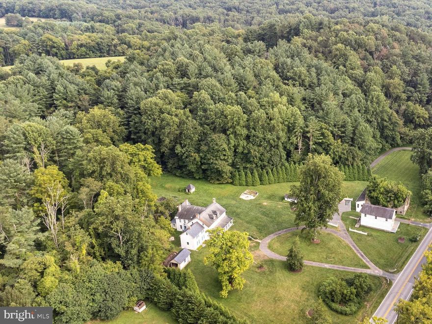 Dating back to the early 1800’s, the remarkable La Grange Estate is centered around a grand Georgian residence atop 2 plus acres- nestled in the heart of scenic Rocks State Park. Once the site of a thriving iron works, the adjoining 5.9 acres (Tax ID 1305043891, included in sale) features a historic general store,  numerous outbuildings, lush grounds and an additional building site for future expansion (Buyer to verify with the county). 

The elegant stone home boasts 11 fireplaces, intricate molding, twin ornate iron mantels in the adjoining kitchen and den, paneled window wells, 10 foot ceilings, wide-plank floors throughout, 6 light-filled bedrooms (a 7th in the cottage), hand-hewn beams, spacious bright rooms for entertaining, updated electric and plumbing, and wiring for a whole-house generator. 

With its own separate entrance and parking lot, the general store at 3810 Rocks Station Road  was most recently a well-frequented antique store (Buyer to verify non-conforming use permit with the county). The potential for a 2-bedroom, 1-bath apartment above the store lends itself to a possible guesthouse or extended family quarters. 

The fully remodeled cottage (left side of the main home) features exposed hand-hewn beams, interior stone walls, and a cathedral ceiling - the perfect separate guest quarters or possible rental. 

The property includes private forested hiking trails east of the main house and beyond the  garden, an outdoor fire pit/grilling area, a charming 1960’s milking parlor and workshop, an Italianate schoolhouse/storage building, fencing around approximately 5 acres, and a separate 1/2 acre fenced dog park. 

Mature arborvitae line the north and south boundaries, affording privacy on the expansive 500 sq ft grand front porch. Panoramic views from the porch and front lawn include the stunning Rocks of Deer Creek, with upper bedroom views of the fabled King & Queen Seat. 

Given his family connections to the Marquis de Lafayette, prominent iron master Isaac Rogers purchased and named the estate “La Grange” in 1834- after the French chateau where Lafayette died that same year. Oral tradition maintains that La Grange iron was used to make the revolving turret of the epochal Civil War battleship the Monitor. Given the estate’s importance in U.S. history, all structures on the grounds have been designated “eligible” for the  National Register of Historic Places. 

More than just an elegant country estate, La Grange offers a rare opportunity to own a piece of American history with endless possibilities for future expansion.