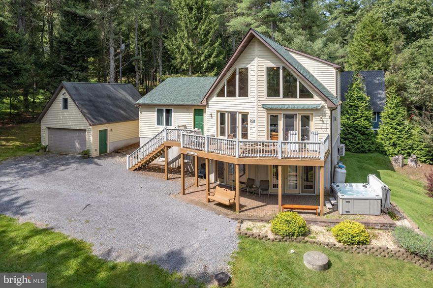 Nestled in the sought-after Sky Valley community at Deep Creek Lake, this beautiful 5-bedroom, 3.5-bath home offers the perfect blend of luxury, comfort, and outdoor living. With nearby lake access and opportunity for a boat slip, you'll enjoy year-round recreation and tranquil waters. Step inside to discover a spacious, open floor plan featuring gleaming granite countertops throughout the kitchen complemented by high-end finishes and thoughtful details. The inviting gas fireplace in the living room adds warmth and ambiance, perfect for cozying up during cooler evenings. The main level includes the primary bedroom with private bath, a well-appointed kitchen with ample storage, a dining area, and a living room that flows seamlessly to a large deck overlooking the hillside pines —ideal for entertaining or simply enjoying the peaceful surroundings. Four additional bedrooms provide plenty of space for family or guests, each designed for maximum comfort and relaxation. The lower level features a large family room, a bar, and abundance of space for game tables. Outdoors, this home shines with a hot tub for year-round enjoyment, a fire pit for evenings under the stars, and a spacious detached garage with a game room above, offering endless possibilities for fun and games. Whether you're entertaining friends or relaxing with family, this property has it all. Located in the heart of Sky Valley, you’ll be just moments from the best of Deep Creek Lake and Wisp Ski Resort's' outdoor activities, from boating to hiking to snow skiing, and close to top-rated restaurants and shops. This property is a true gem—whether you're seeking a year-round mountain retreat or a vacation getaway, you won't want to miss the opportunity to call it home. Boat slip availability through the association! Sky Valley is one of the most special communities at the lake with its own beach area, kayak/canoe racks, boat ramp, pond, sport court, and playground area!