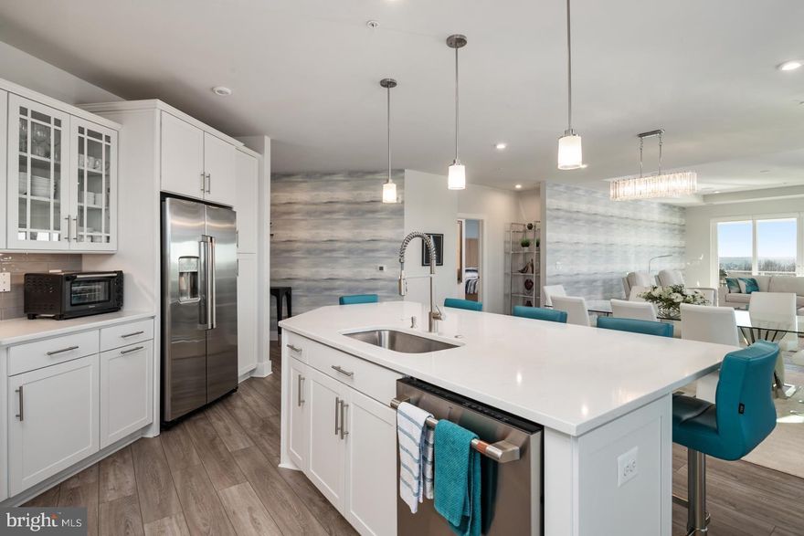 Four Seasons at Kent Island is an active 55+ community on Maryland's Eastern Shore, offering island resort-style & maintenance-free living at its finest! This Severn model is a spacious and airy 3 bedroom, 2.5 bath penthouse, end-unit boasting an expansive open floor plan with over 2600 square feet of luxurious living space. This home features a lavish gourmet kitchen and dining area, a huge great room with sliding door access to a large corner balcony. 
As you enter this home through an inviting foyer you have direct access through French doors to a home office/guest bedroom. 
The distinguishing features of this home include a state-of-the-art kitchen equipped with GE Energy Star stainless steel appliances, multi-functional range top with a Wi-Fi Connect Enabled hood, upgraded quartz countertops, oversized center island with pendant lighting, upgraded staggered custom cabinets with slide out drawers and brushed nickel hardware. Whether you’re preparing a quiet meal for two or hosting a lively gathering, this kitchen is as functional as it is beautiful.
The homes’ dining and living areas extend from the kitchen with an open, yet intimate layout, bordered with oversized windows allowing for lots of natural light.  Levolor Cellular Shades provide light control and privacy, when needed. A very special feature is the  Surround Sound Home Theater with an 85 inch flat screen TV. The entire home theater will be yours to enjoy.
The fantastic owner's suite boasts a decorative wall mounted designer panel, has an adjoining sitting room with access to the balcony, an owner's spa bath and 2 oversized walk-in closets. 
Two large secondary bedrooms are located in a separate wing of the home and each feature a walk-in closet and share a Jack and Jill bath. This section of the home has a separate laundry room with built-in cabinets and a GE SMART washer and dryer. 
Special features throughout the home include custom closets by Closet America, Candice Olson wallpaper, black-out blinds in all bedrooms, remote control blinds on slider leading to balcony, and tray ceilings throughout the home - a benefit of being a penthouse unit. Quartz countertops and luxury ceramic tile are included in all baths.
This home also has the LARGEST garage in the building, and the LARGEST storage room in the building,  which is a few short steps from the elevator. 
This MUST SEE condominium is ready for immediate delivery and shows better than a model, better than new – the thought, planning and design that have gone into this home is second to none!
KEEP IN MIND THIS SEVERN MODEL, WITH OVER 2600 SQUARE FEET OF LUXURY LIVING SPACE, IS AVAILABLE TO YOU NOW. PRESENTLY, THERE IS A 7-10 MONTH WAIT FOR THE COMPLETION OF NEWLY CONSTRUCTED SEVERN MODELS, BUT THIS UNIT IS MOVE-IN READY WITH PLENTY OF HIGH-END DESIGNER FEATURES AND UPGRADES ALREADY INCLUDED.  Award winning 24,000 Square Foot Clubhouse with Stunning Chester River Views! Fantastic amenities include an  infinity pool, indoor pool with, fitness center, library, game room,  fire pits, tiki bar equipped with refrigerators, sinks and television monitors, pier with transient boat slips, walking paths that link to the Cross Island Trail, pickleball & tennis courts, bocce, dog park, and an outdoor amphitheater for live music and movie nights. The community lifestyle director will keep you busy with daily activities such as yoga, a variety of exercise classes and an assortment of clubs including biking, billiards, book club, baking, mahjong, environmental club, trivia night and more. In addition to the weekly and monthly activities, residents can enjoy crab feasts, and holiday gatherings throughout the year. This development is an unrivaled, amenity-filled, resort-style experience with convenient access to Annapolis, DC, Baltimore, and BWI. Kent Island offers multiple dining and shopping options, a nearby outlet mall, and a 6.5 mile cross-island trail surrounded by views of the Chester River.