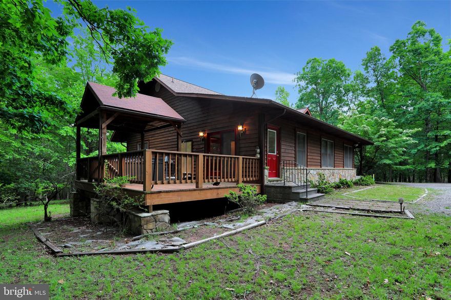 Beautiful Contemporary move in ready raised ranch home on 2 acres in a gated clothing optional community with mild winters and resort adjacent. This Home is perfect for refuge and relaxation 2 hours outside the DC or Pittsburgh metropolitan area or just 40 minutes to Winchester Medical Center.  With 2500+ sq ft of living space, including separate home business space, 3 Bedrooms, 2.5 baths and a fabulous open floor plan. Entry into the Great Room, with Cathedral Beam ceilings, stone wood burning fireplace, large Dining Area and fully equipped Kitchen with upgraded counter-tops, built in wine fridge, and attached over sized pantry. Master Bedroom with luxury bathroom, complete with separate sinks, jetted soaking tub, two person shower, and walk in closet. Additional Bedrooms, have private entrance for rental or home business. High speed internet available, free standing well, septic and automatic generator makes property perfect as a second home, retreat center or refuge from pandemic. Full clean heated unfinished basement with 2 car garage for workshop or build out.  Wooded lot for privacy and wrap around porches for outdoor entertaining and Jacuzzi - sit on the front porch, enjoy the screened-in porch, or gather on the large rear deck with covered area over the 8 person hot tub.  Solar panels cover most utility cost savings and whole home generator kicks in for any power loss. The community of Somerset is family friendly, clothing optional  and has easy access to hiking trails, indoor and outdoor pools and children’s playground at Avalon Resort.