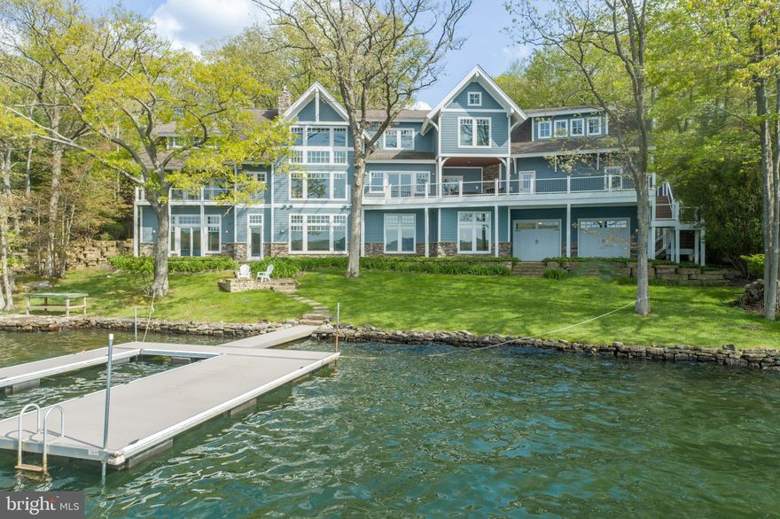 This luxurious lakefront masterpiece with an extraordinary setting has the absolute best unobstructed, expansive views of Deep Creek Lake! Built by one of the area's most respected builders, this custom built modern rustic lakefront home with a perfectly arranged floor plan for the property has 6 bedrooms, 5 full baths, and 2 half baths with high end features throughout including hardwood flooring, high ceilings, oversized windows allowing in an abundance of natural light, granite counters in the kitchen and all bathrooms, tiled showers, wood stairs, radiant floor heat, 3 fireplaces, 2 laundry areas, and exterior stone. This lakefront setting is truly one of the best at Deep Creek - take in dramatic sunsets from nearly every room in the house or outside on the large expansive lakeside deck with fireplace and composite decking.  The 150 feet of lake frontage has a stacked natural stone wall and rock shelve lake bottom that keeps the deep water clear at the private Type A boat dock and allowing pleasant, easy access for swimming. The main level features a primary bedroom with a vaulted beamed ceiling, private bath with jetted tub and tiled shower, and a lakeside balcony to take in the stunning water views. The gourmet kitchen is an entertainer's dream with granite counters and stainless Sub-Zero Wolf appliances. The living room features a vaulted ceiling with wood beams and a stone fireplace that overlooks the lake at its widest point. The upper level features 2 more bedrooms, 2 more full baths, and an oversized room that is a combination bedroom and office area.  The lower level has 2 additional bedrooms, 2 full baths, a lakeside family room with fireplace and wet bar, a separate game table room, a large storage room, and a lakeside entrance room with laundry for coming up from the lake. The heated oversized attached garage has tall garage doors and driveway made with pavers. There is also a second oversized garage on the lakeside for all your lake toys.  Centrally located within just a few minutes to the Deep Creek Lake State Park for hiking and kayaking - and Wisp Ski Resort for winter-time fun. This is your chance to own a true legacy lakefront property at Deep Creek Lake!