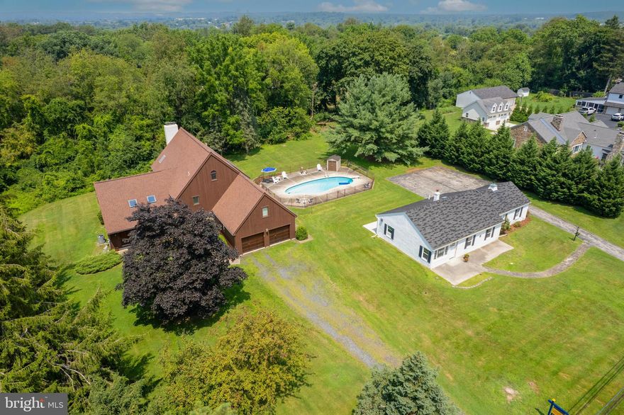 Set Sail for your Dream Property! This Soaring Contemporary 5BR 2.5B Custom-Built Estate (1982/1993c. Addition) includes a separate charming, newly re-built 2 BR, 1B single-story Cottage, a terraced Pool, and Garages offering Parking for Four+++.  Surrounded by picturesque Pennsylvania landscapes, abutting idyllic horse trails, and set amongst an architectural showcase along Johnson Road- this rare and wonderful Plymouth Meeting property is available now after 7+ decades of impeccable stewardship by a treasured local family. Thoughtful design has been professionally executed to maximize today's needs for live, work, and play spaces. Whether providing maximum flexibility for a growing multi-generational brood; or serving your varied vocational/ avocational interests; perhaps allowing for passive rental income...this stunning, two-structure 'Compound' delivers! Choose from not just one but two separate Driveways to enter this lush property. The thrilling, warm-wooded Exterior of the Mainhouse- Modern yet timeless- has just been expertly re-stored for its next new owners. Additionally, the Interior of the freshly white-washed adjacent Cottage (1945c.)  has been completely re-built- stripped to studs, and now to a finished, beautifully re-designed floorplan... reflecting today's exacting standards with open ease. A glamorous Pool House? An Artist's Retreat; or expanded first-level living for loved ones? OR, a separate fully contained 2BR, 1B Rental (new Washer & Dryer incl.),  w/ Central AC and an attached 2 Car Garage...? Our dynamic and ever-changing lifestyles need wonderful options such as these... Glorious Parking is abundant at 1911 Johnson Rd.! Pulling up to the Main House you encounter richly-stained, quality-constructed additional Parking Bays offering civilized inside access. The Home's Great Room is heart-skipping, with its impactful honey-hued Oak-beamed masts above, grounding stone wood-burning Fireplace focal point, and adjacent skylit Atrium with views to the Pool beyond. Arch-shaped picture windows abound- each pretty as a picture framed with unpainted Oak, highlighting your own gorgeous green and private World beyond...A step up to the Kitchen allows for a fantastic perch- never too far from the ebb and flow - yet still tucked away, as needed. Dine in an intimate setting, or choose to lay out a grand banquet anywhere throughout the versatile 1st level. The lower level is vast and excites the imagination with room to make your own- Wine Cellar, Media Room, high-ceilinged Workshop? Have a go! Serenely Carpeted underfoot- ascend either of Two staircases to connect with the 5 Bedroom options above. Playfully shaped light-filled rooms combine with peaceful traditional bedrooms. A Primary Suite delights- containing a Sitting Room with Fireplace, Walk-in Closets, a Spiral Staircase with a Balcony view from the sleeping Loft above. Also, makes for a wonderful bi-level Family Room for all to enjoy-perhaps. Just freshly skim-coated and painted throughout the house, where required- there are still fantastic opportunities to add your own decorator's touch. Along with the Video Tour, use the convenient 3D Mattersport provided to start imagining your projects to be....