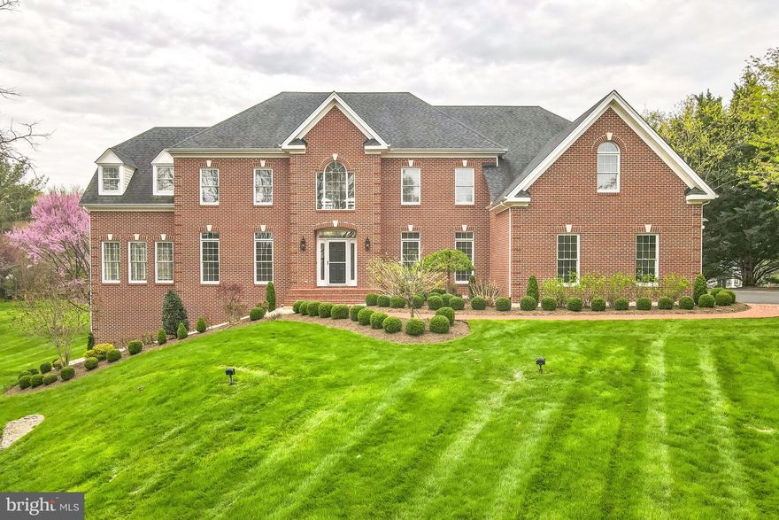 **Offer Deadline: Sunday, April 27 at 3pm**Tucked deep within 3.28 acres of open, park-like grounds, this stately custom-built brick colonial welcomes you with timeless charm and unforgettable curb appeal. A long, tree-lined driveway leads you through manicured landscaping to a home of true presence and timeless design. Inside, the home is equally impressive—flooded with natural light and framed by picture-perfect views from nearly every room.

Step inside to a grand two-story foyer, where an elegant curved staircase greets you. Refinished hardwood floors flow throughout the main level, guiding you through formal living and dining spaces thoughtfully designed for entertaining. The living room opens through double doors into a spectacular conservatory wrapped in windows—offering uninterrupted views that make it feel like you’re outdoors. Nearby, a spacious office with bay window overlooks the backyard and sits adjacent to a full main-level bath.

At the heart of the home, a soaring two-story family room features a striking wall of windows and a dramatic floor-to-ceiling brick fireplace. The gourmet kitchen has been refreshed with painted cabinetry and updated appliances, and offers a large center island, double ovens, walk-in pantry, and a quintessential window-over-the-sink view of the rolling green lawn. A sunny breakfast area leads to a window-filled sunroom and onto the rear deck—perfectly positioned to take in the sweeping lawn and private backdrop. Off the kitchen, a mudroom and laundry area connect to the three-car side-load garage with additional access to the deck.

Upstairs, the layout is a rare find: five generously sized bedrooms, each with ensuite access. The primary suite is privately set apart and features double-door entry, tray ceilings, a sitting area, two walk-in closets, and a spacious bath with dual vanities, corner tub, separate shower, and private water closet. Four additional bedrooms are thoughtfully laid out in pairs, with each pair sharing a Jack-and-Jill bathroom—an ideal setup for both comfort and functionality. One of the bedrooms is oversized, featuring a cozy sitting area and dual closets. A rear staircase provides added convenience, while the gallery overlook captures views of both the sunlit foyer and grand family room below..

The walkout lower level offers more than 2,300 square feet of untapped potential. With full-size windows, plumbing rough-in for a full bath, and direct access to the backyard, the space is primed to become a home theater, gym, guest suite, or ultimate entertaining space—whatever suits your vision.

A home that offers timeless design, incredible space, and a setting that feels worlds away—yet is just minutes from downtown Leesburg, local dining and shopping, top-rated parks and trails, wineries, and Dulles Airport. Whether you’re enjoying quiet mornings at home, gathering with friends, or making the most of all Loudoun County has to offer, this is where quiet, country-like living meets everyday convenience. **We kindly ask that you refrain from walking the lot unless you have a confirmed showing scheduled. Thank you for respecting the owner's privacy!**