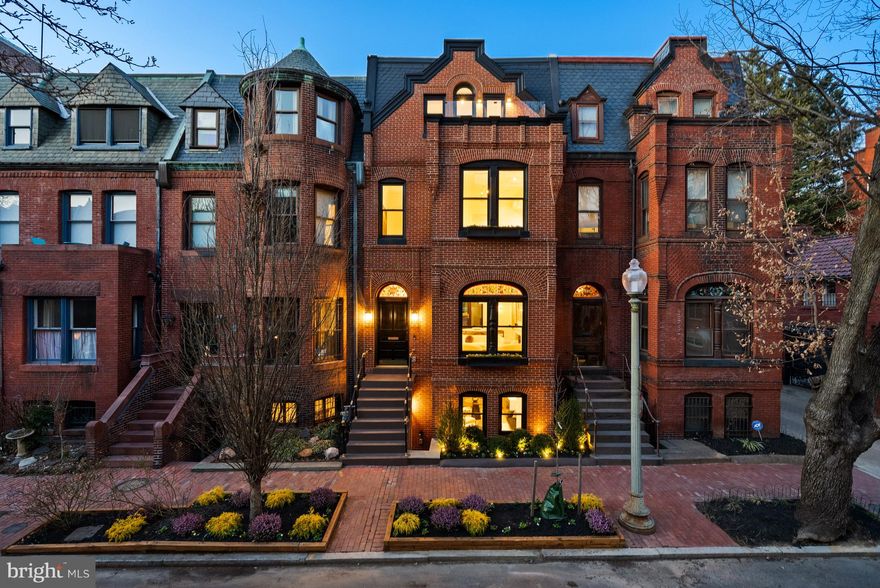 OPEN HOUSE ON FRIDAY MOVED TO SATURDAY DUE TO RAIN. HISTORIC ELEGANCE MEETS MODERN LUXURY! Nestled in the heart of Dupont Circle on the renowned Harvey L. Page block, 1611 Riggs Place NW stands as a testament to Washington, DC’s rich architectural history. This Queen Anne-style residence, built in 1889, is part of the last remaining complete block of original red-brick homes in the city. While the historic front façade has been preserved with the utmost care by District495, the interior has been reimagined to meet the highest standards of modern luxury living. Boasting 3,685 square feet across 4 stories, this beautiful home features 5 Bedrooms, 4.5 Bathrooms and tasteful interior design that harmoniously blends timeless elegance with modern sophistication. A full gut renovation turned masterpiece with every detail crafted and curated, from the soaring  ceilings, to the timeless White Oak hardwood floors, the hand-picked marble selections, custom millwork, Waterworks fixtures, and designer lighting by Visual Comfort, Hudson Valley, and Restoration Hardware throughout. The chef’s Kitchen is a true showstopper, outfitted with premium Thermador appliances, custom two-tone inset cabinetry, premium marble countertops, backsplash and 9-foot waterfall island, and is anchored by a magnificent ILVE Majestic Range. The second level is dedicated exclusively to the Primary Suite, complete with a separate office, a sitting area, and a Dressing Suite that is a work of art with its custom-built cabinetry. The Primary Bathroom is a luxurious haven, boasting Waterworks fixtures, dual vanity sinks, a large soaking tub, and a spacious dual shower with a recessed rainfall shower system. The upper-level features 2 additional Bedrooms, 2 en-suite Bathrooms, and an Office/Den with convenient wet bar and roof deck access overlooking the rear of the home. The lower level of this stunning property offers great flexibility with its full Kitchen and separate entrances, serving as additional family gathering space or a potential one-bedroom rental opportunity, making it an excellent investment. The beautiful back patio provides an ideal setting for relaxation or outdoor entertainment. This home features not one but three outdoor spaces – both North and South facing. Enjoy the convenience of two full-size secure parking spaces outfitted with two electric charger hookups. This magnificent home is equipped with all the extras needed for entertaining guests, including 3 sets of washers and dryers, audio speakers throughout the house, and state of the art Wi-Fi appliances and switches; leaving no detail overlooked and no expense spared. This rare offering presents a unique opportunity to own a piece of Washington’s architectural heritage without sacrificing the conveniences of 21st-century living. Experience timeless elegance in one of the city’s most coveted historic enclaves.