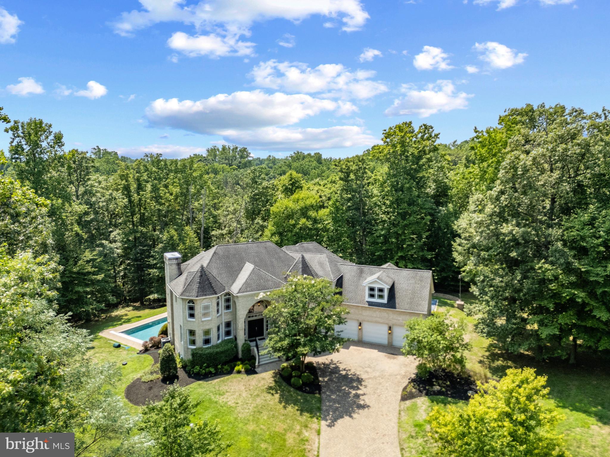 Spectacular all-brick colonial home with pool and sport court sits on almost 3 acres of beautiful sprawling grounds. As you approach down the tree-lined road, the grandeur of this residence becomes evident, promising an unparalleled lifestyle. Step inside to find a home that effortlessly blends elegance with functionality. The main floor welcomes you with a formal living space/bonus room and office/library with built-in shelving; tranquil spots for work or relaxation, both are complimented by the curved staircase and 2 story foyer. The heart of the home reveals an open floor plan where the family room and dining area with coffered ceilings seamlessly connects to a spacious gourmet kitchen with enormous island and a cozy breakfast nook, making it the ideal space for everyday living and gatherings of all sizes. High end appliances, and a plethora of cabinets and counter space are sure to please the chef in the family. A convenient powder room, mudroom and laundry room add to the home's practicality. Ascend to the upper level, where you'll discover a serene and spacious primary bedroom with fireplace and spacious ensuite bath, a true retreat at the end of the day. An additional ensuite bedroom provides privacy for guests, while two more large bedrooms share a well-appointed bath, ensuring comfort for everyone. The bonus room on this floor is designed for entertainment and fun. The ideal hang out room for young and old. The lower level contains plenty of space for whatever you can dream up! An open floor plan with tons of storage, an additional primary ensuite bedroom with adjacent sitting room, and direct access to the pool and backyard; the finished basement can be tailored to meet your family's unique needs and offers flexible living arrangements, perfect for extended family or visitors. Outside, the property continues to impress. A main level rear deck overlooks the stunning inground saltwater pool with an automatic cover, sun shelf and expansive pool deck, creating an inviting space for outdoor gatherings. The wide lot backing to woods on a peaceful cul-de-sac ensures privacy, making it a secure haven for relaxation. Additional features include a 3-car attached garage, expansive paver patios and sport court; a space for everyone in the family to enjoy! This home is more than just a place to live; it's a private oasis where you can unwind, and enjoy life to the fullest, while being conveniently located just off Generals Highway which provides quick access to Downtown Annapolis, BWI, DC and 97. Welcome Home!
