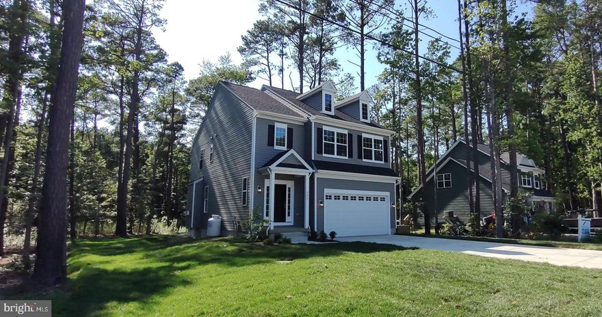 The Denton Model by HowMar Homes a is 2,140 sq ft with 4 Bedrooms and 2 1/2 Baths.  Nestled in the woods it offers extra privacy and tranquility for the homeowner.  When you walk into the home the first thing you will notice is the 9ft ceilings and upgraded trim on the walls.  As you enter the Great room you are greeted by a beautiful Fireplace with custom surround.  Take a step further and the open floor plan seamlessly transitions into the kitchen and dining Area.  The Kitchen includes a large Island, Granite Countertops, and smart stainless-steel appliances. There is also a charming deck just off the dining area if you prefer to eat outside.  The upstairs is Highlighted by the spacious Owner’s Suite that features a large walk-in shower with bench.  As a bonus the 4 bedrooms come equipped with ceiling fans.  
Kent Island is the quintessential place to live for those who love the outdoors.  This home is within walking distance of the Romancoke pier, perfect for the fishing and kayaking enthusiasts.  There are also many Parks and Trails for those who enjoy hiking and recreational sports.  Kent Island is one of the most lucrative places to purchase a new home as it has one of the highest appreciating markets in Maryland. HowMar Homes is known as one of the most reputable builders on the eastern shore and includes a 5-year warranty with all of their homes. Act now and receive an additional $5,000 towards closing assistance or a rate buy down. To learn more about HowMar Homes or to see one of their many glowing testimonials please visit their website. Disclosure: Photos have been added with A.I. Generated Furniture.